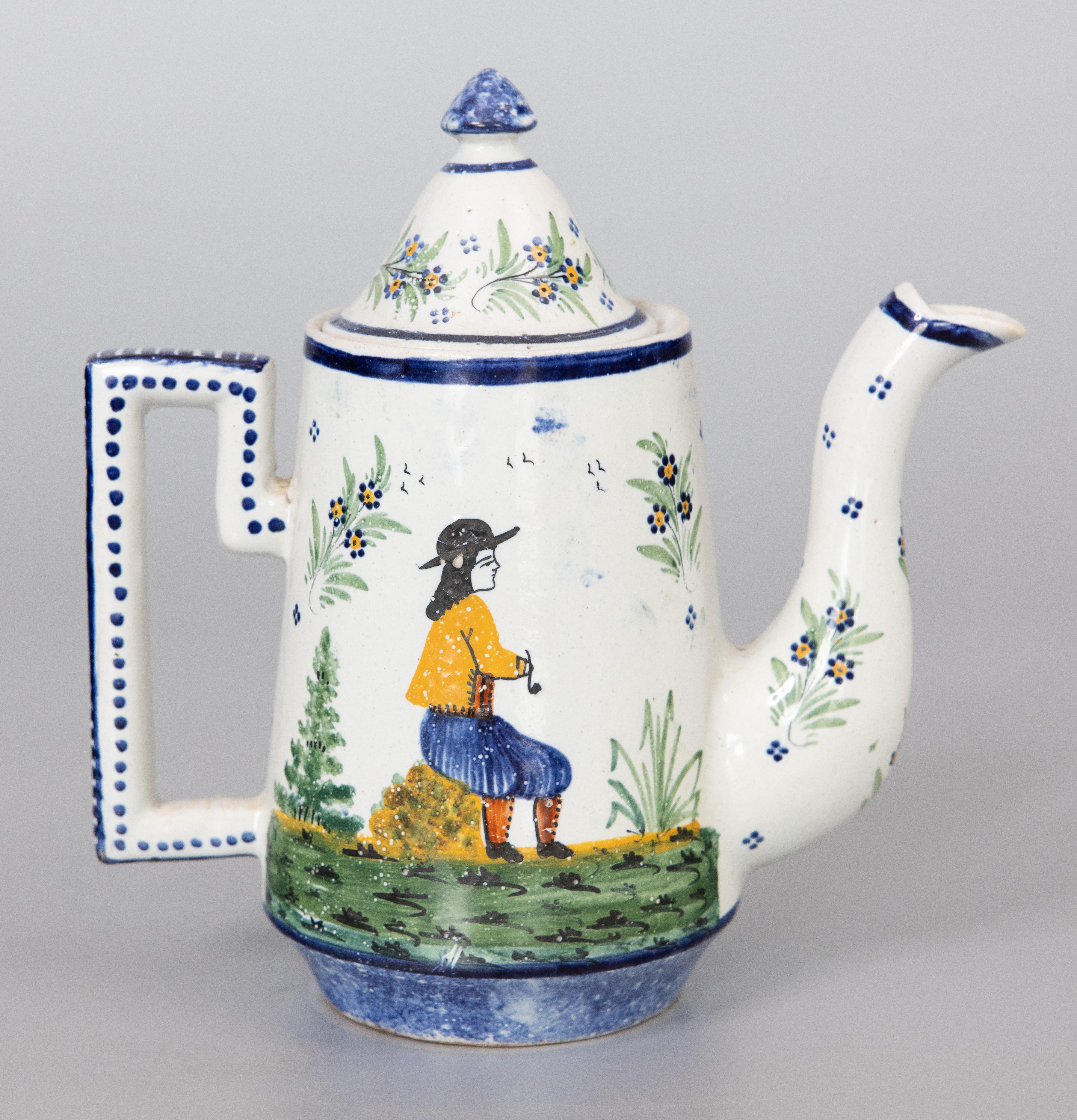 A superb antique French provincial faience Quimper lidded teapot, circa 1890. The base is signed HB Quimper for the Hubaudière Potteries. This charming tea pot depicts a young Breton woman picking flowers and the opposite side depicts a young man