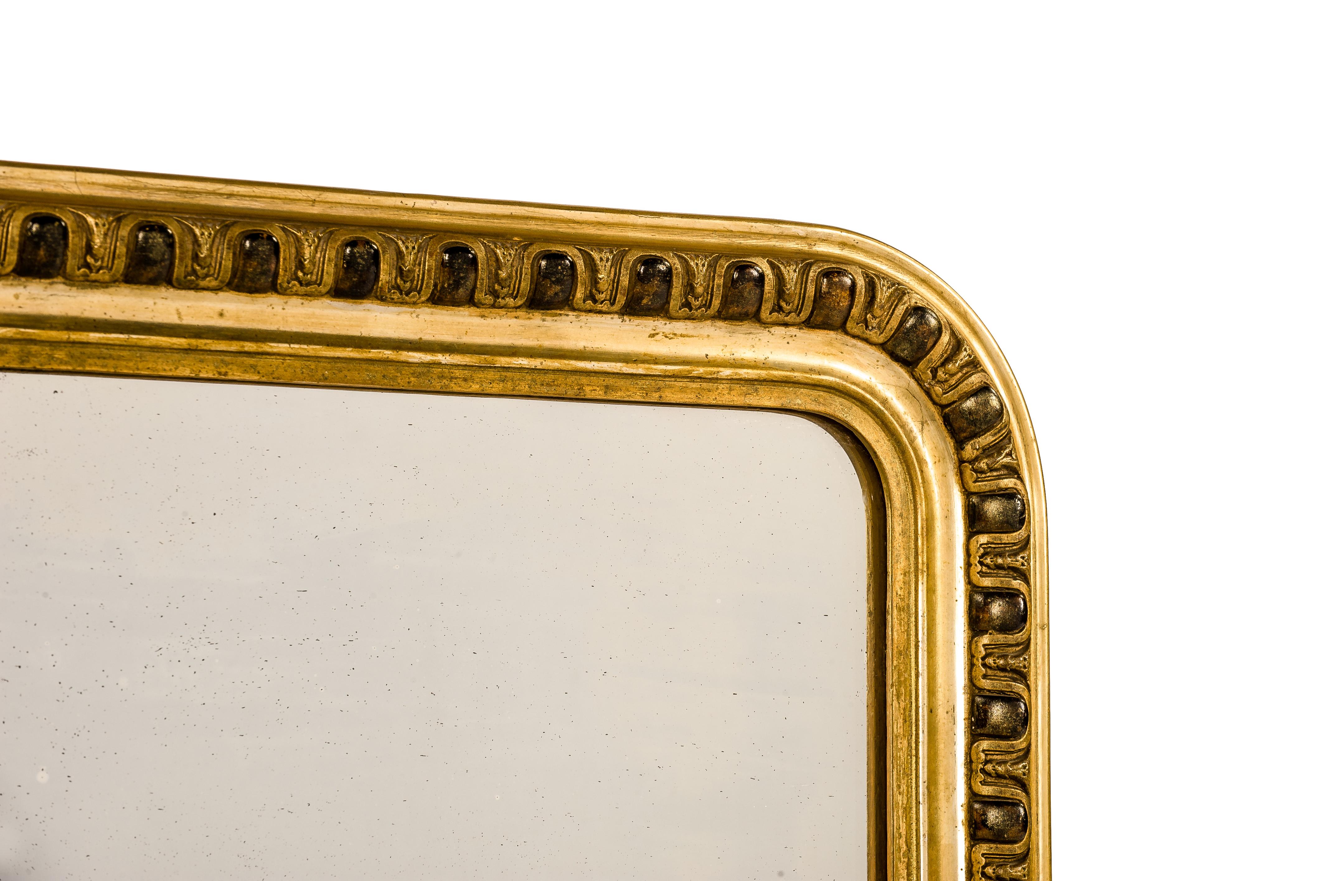 This beautiful antique mirror was made in France around 1880. The mirror has the upper rounded corners typical for a Louis Philippe mirror. The silver nitrate silvered mirror plate is original to the piece. The plate shows many small speckles that