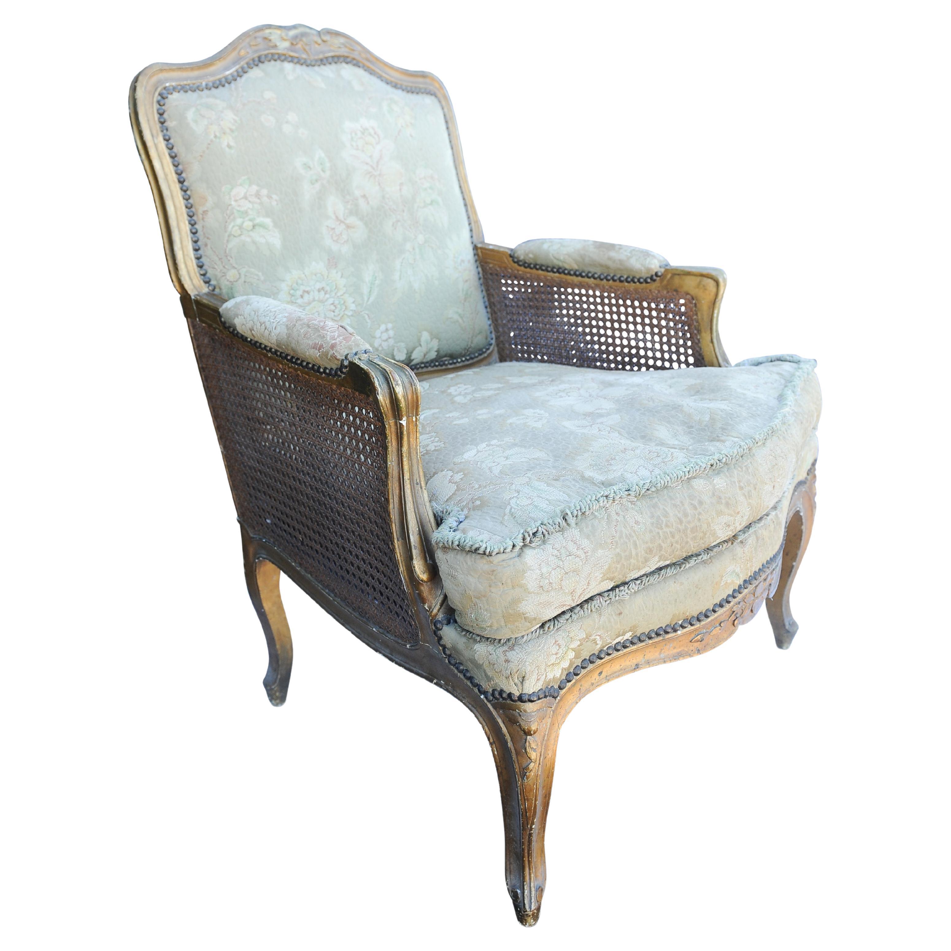 Antique 19th century French gilded Bergere armchair with stud detailing.
Silk Damask Cushions with tassel borders.
Embroidered hardBoard with cane surround.
Louis XV Design.

Height to arms 68cm Height to seat 37cm (43cm to cushion)