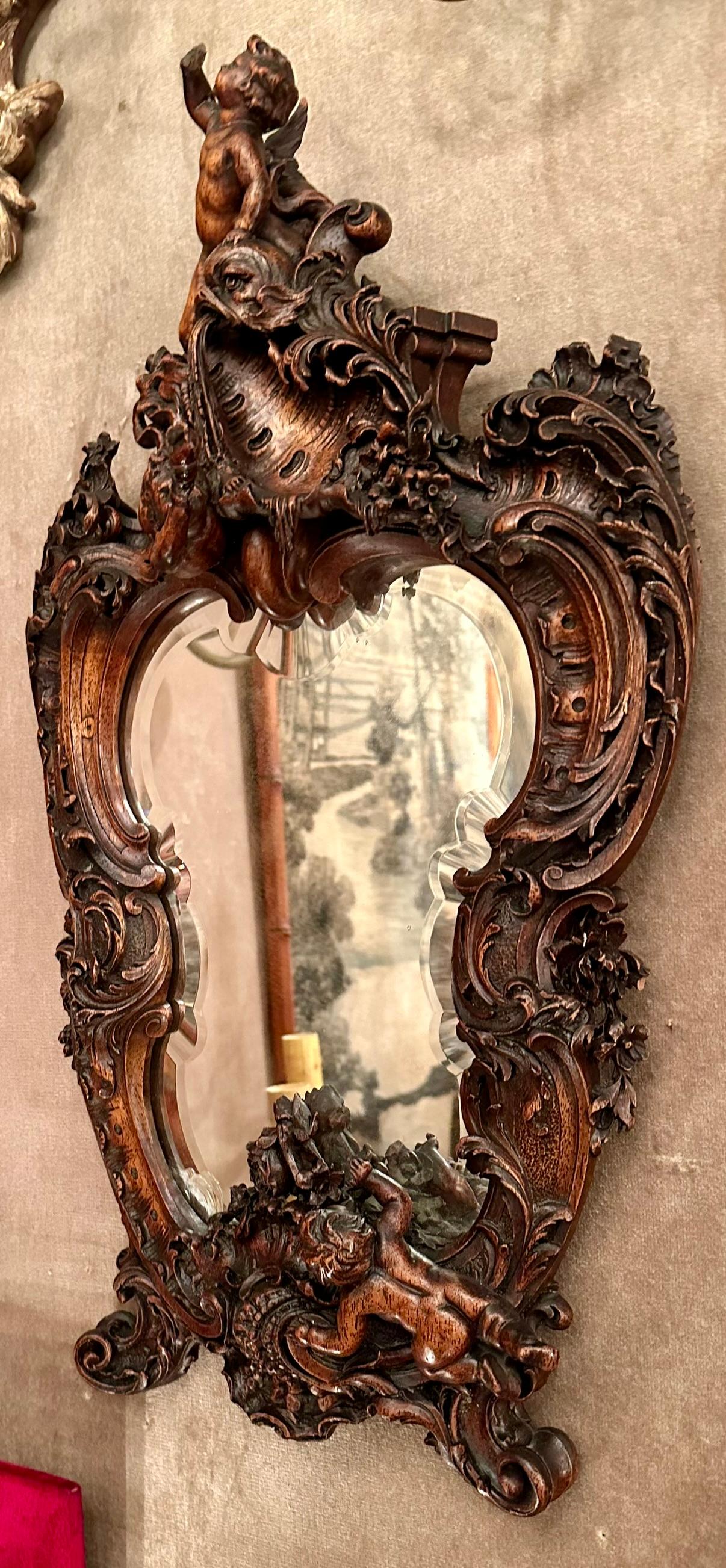 Miroir ancien du 19ème siècle en noyer très sculpté avec biseau, Circa 1865-1885.