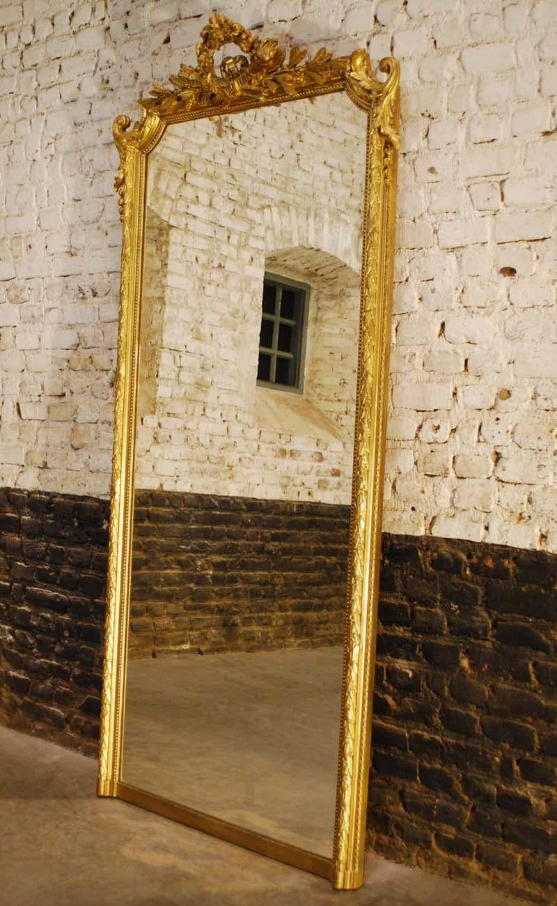 This tall and slender mirror is made in the area around Paris in circa 1870.
It has all the design features of the Louis Seize style such as the elaborate cartouche that depict the royal symbols of Louis XVI. The arrows of justice crossed with a