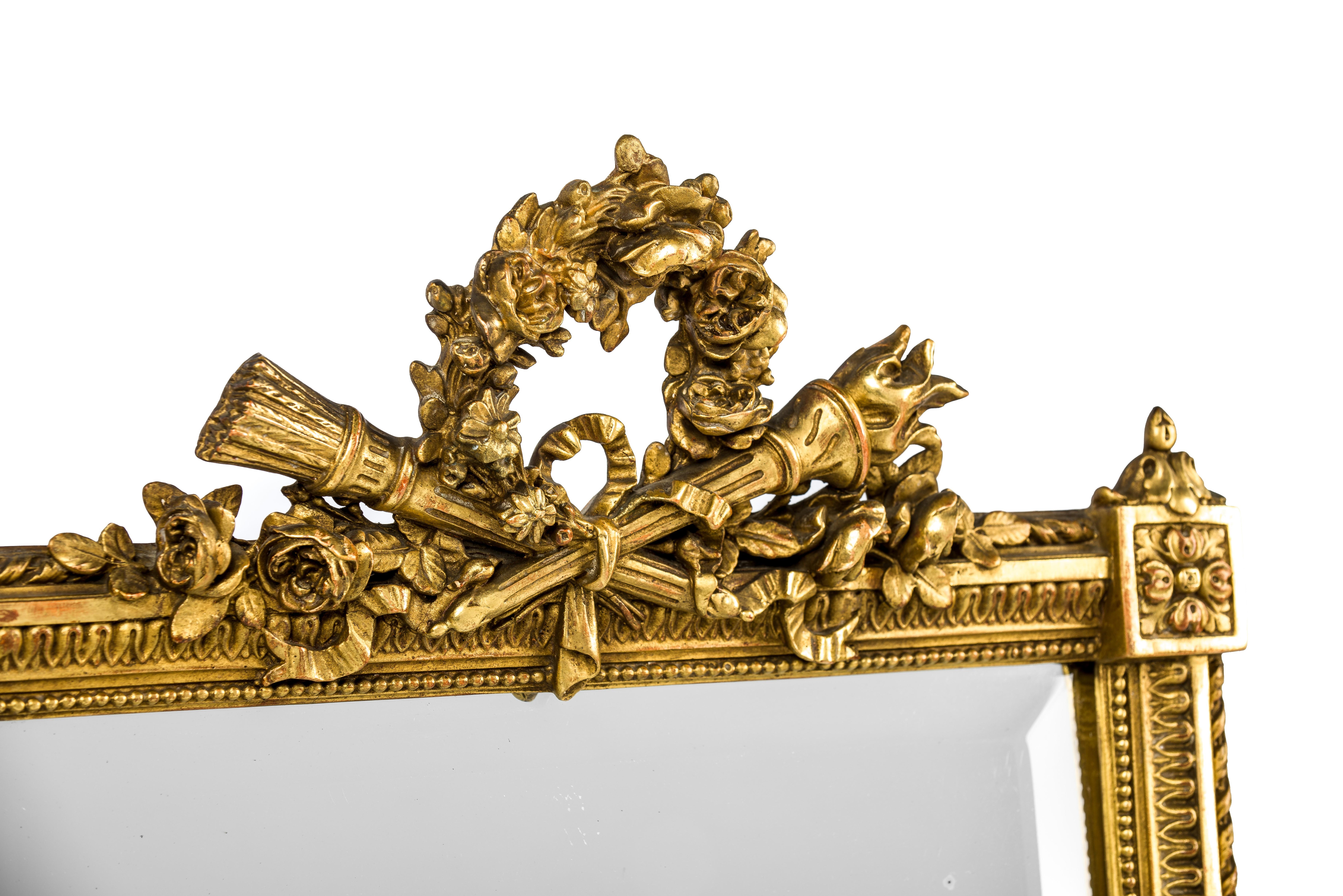 A beautiful French Louis XVI or Louis Seize mirror was made in central France around 1870. The square mirror frame and the detailed ornamentation are typical for this period and style. The mirror frame was adorned with an elaborate crest on top that