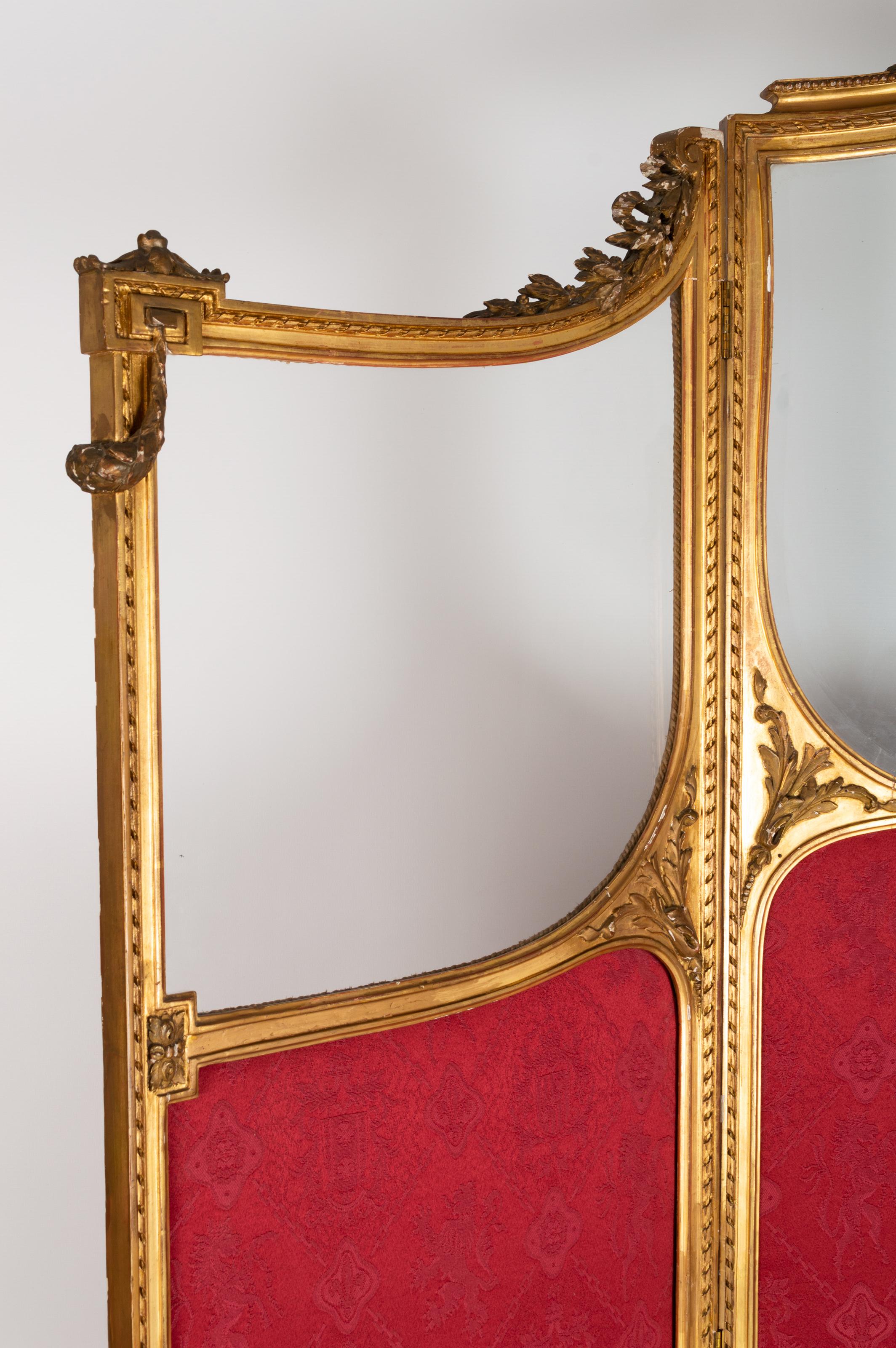 Antique 19th Century French Louis XVI Stye Gilt Three Panel Screen Room Divider

A gilt-framed three-fold screen, c.1890, Continental, the shaped top with leaf and ribbon moulded cresting, shaped bevelled glass mirror panels, above fabric