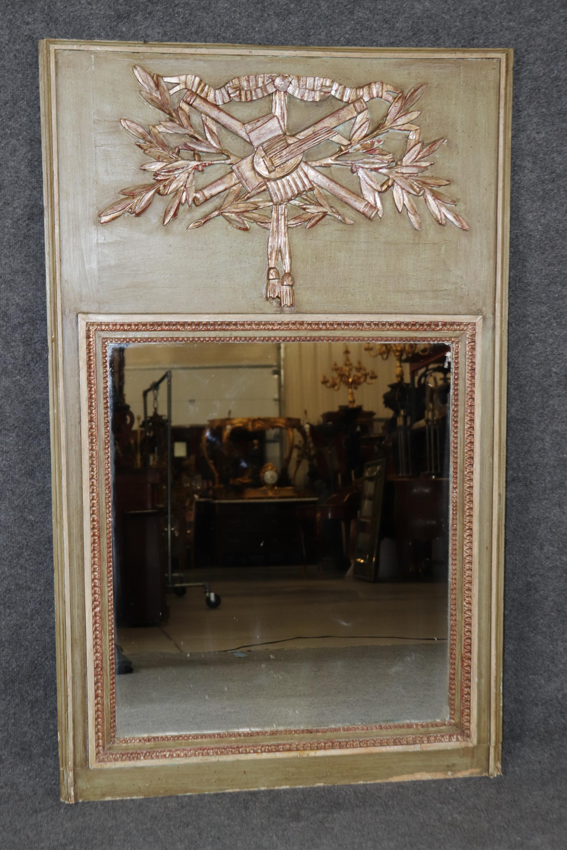 Dimensions - H : 55 1/2 in W : 34 po D : 1 1/2 po 

Magnifique miroir trumeau ancien de la fin du XIXe siècle, de style Louis XVI, délicieusement sculpté et recouvert d'une peinture gris-vert raffinée, avec d'élégants accents dorés à l'argent. Cette