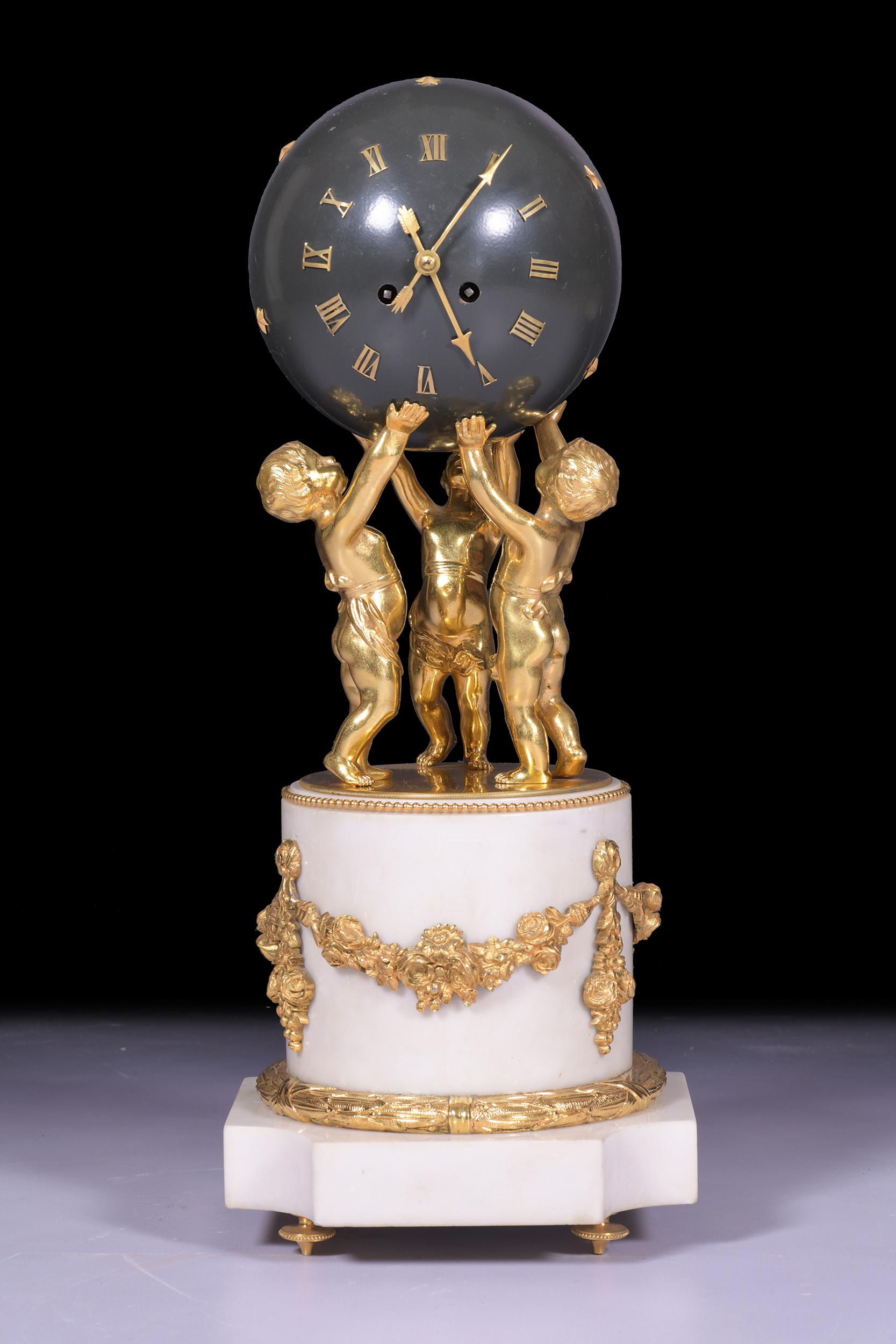 A magnificent & most unusual French marble figural globe clock, the spherical shaped case forming the dial with applied Roman numerals, and arrow hands supported by three dancing putti on cylindrical half column pedestal with applied ribbon tied