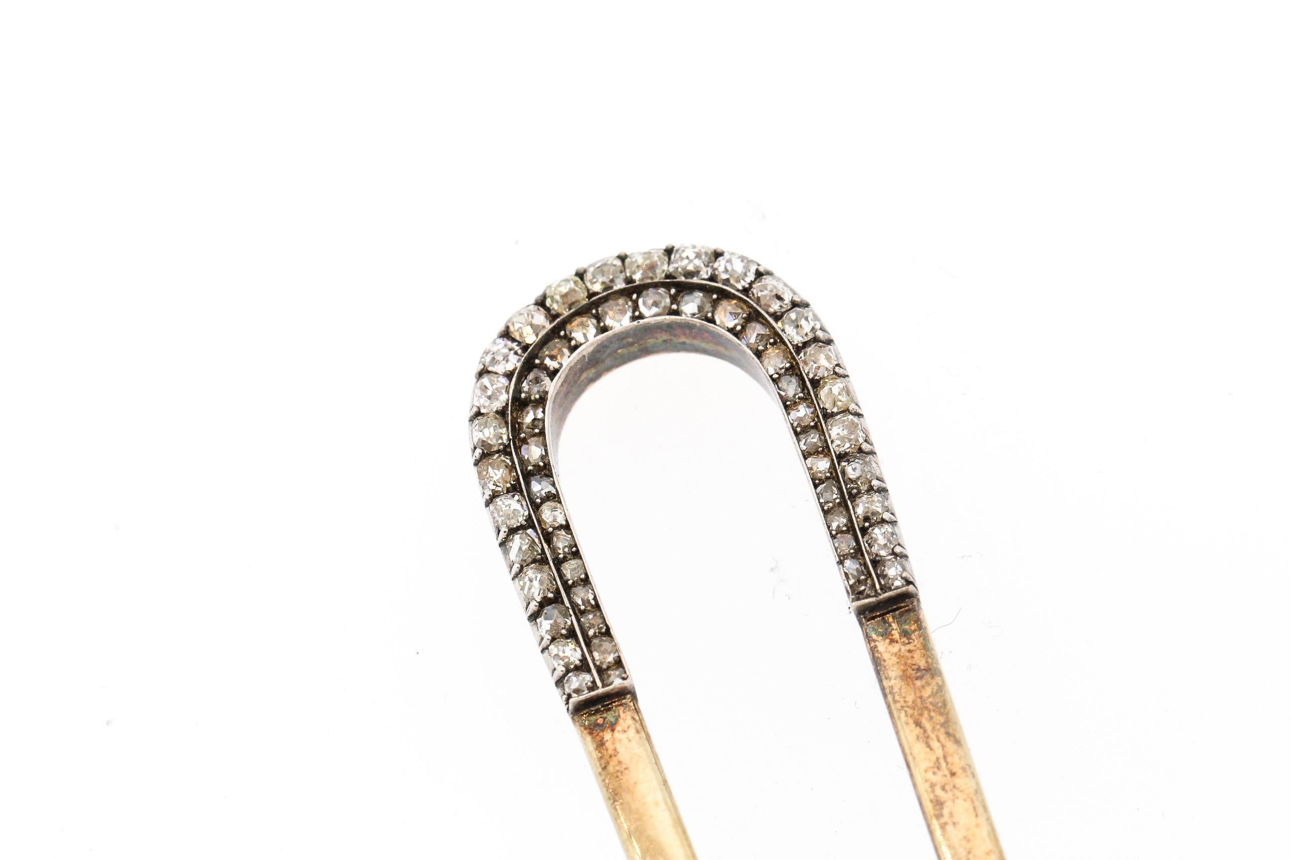 A French 18k gold and silver hair pin set with old mine cut diamonds and rose cut diamonds. What could be more chic that having a touch of sparkle peeking out from your French twist? The hair pin is set with 65 diamonds weighing about 1.75 carats.