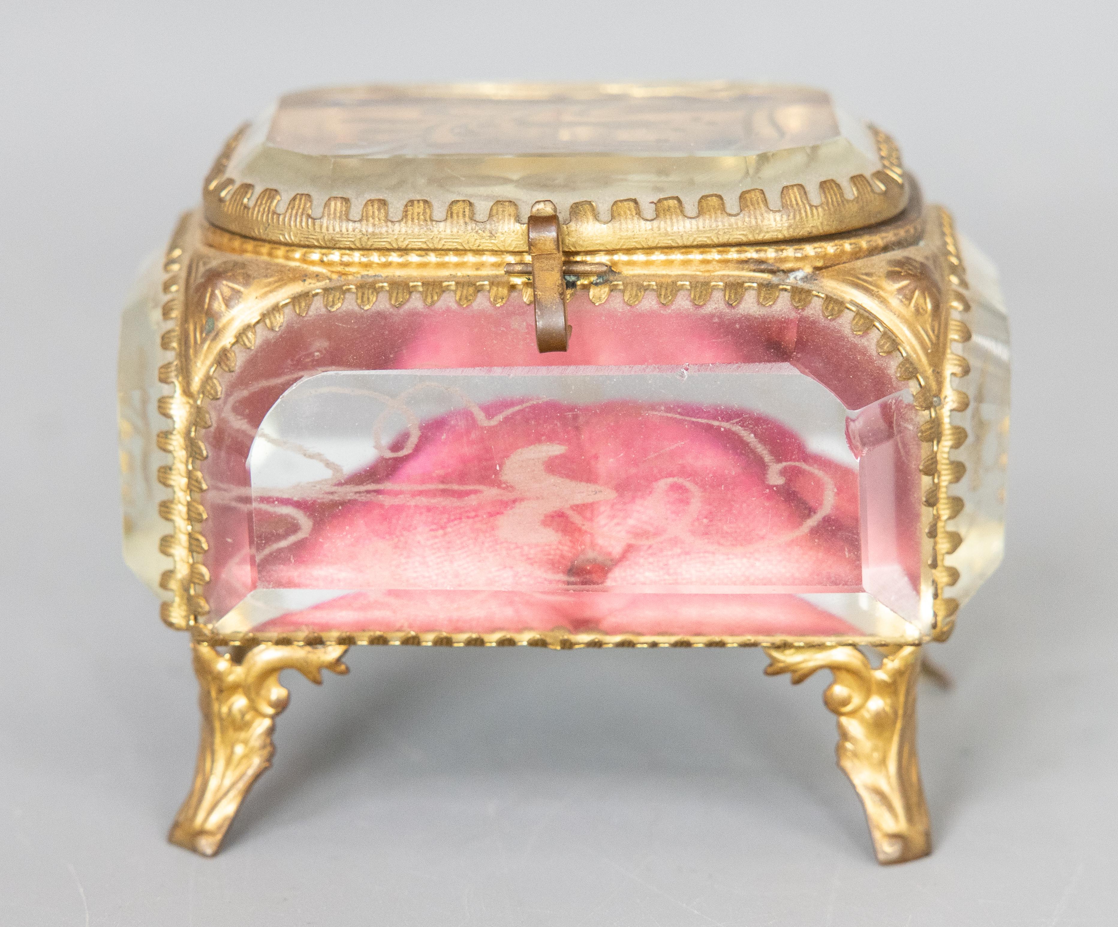 Preciosa caja de baratijas de cristal ormolu del siglo XIX, circa 1860. Esta caja en miniatura tiene el forro original de seda empenachada, grueso cristal biselado con grabado floral, intrincados detalles de latón dorado y patas ornamentadas con
