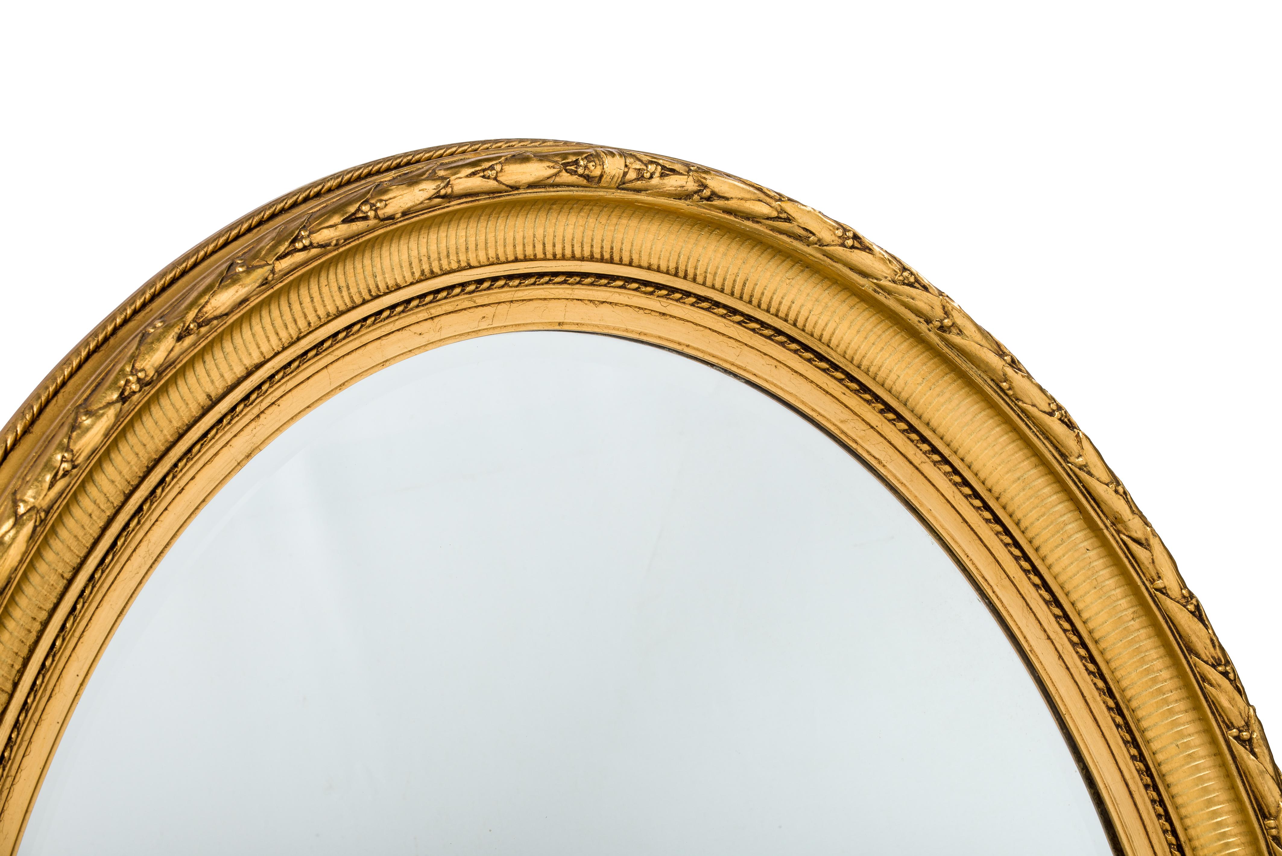 Français Antique miroir ovale français du 19ème siècle, doré à la feuille d'or Louis Seize ou Empire en vente