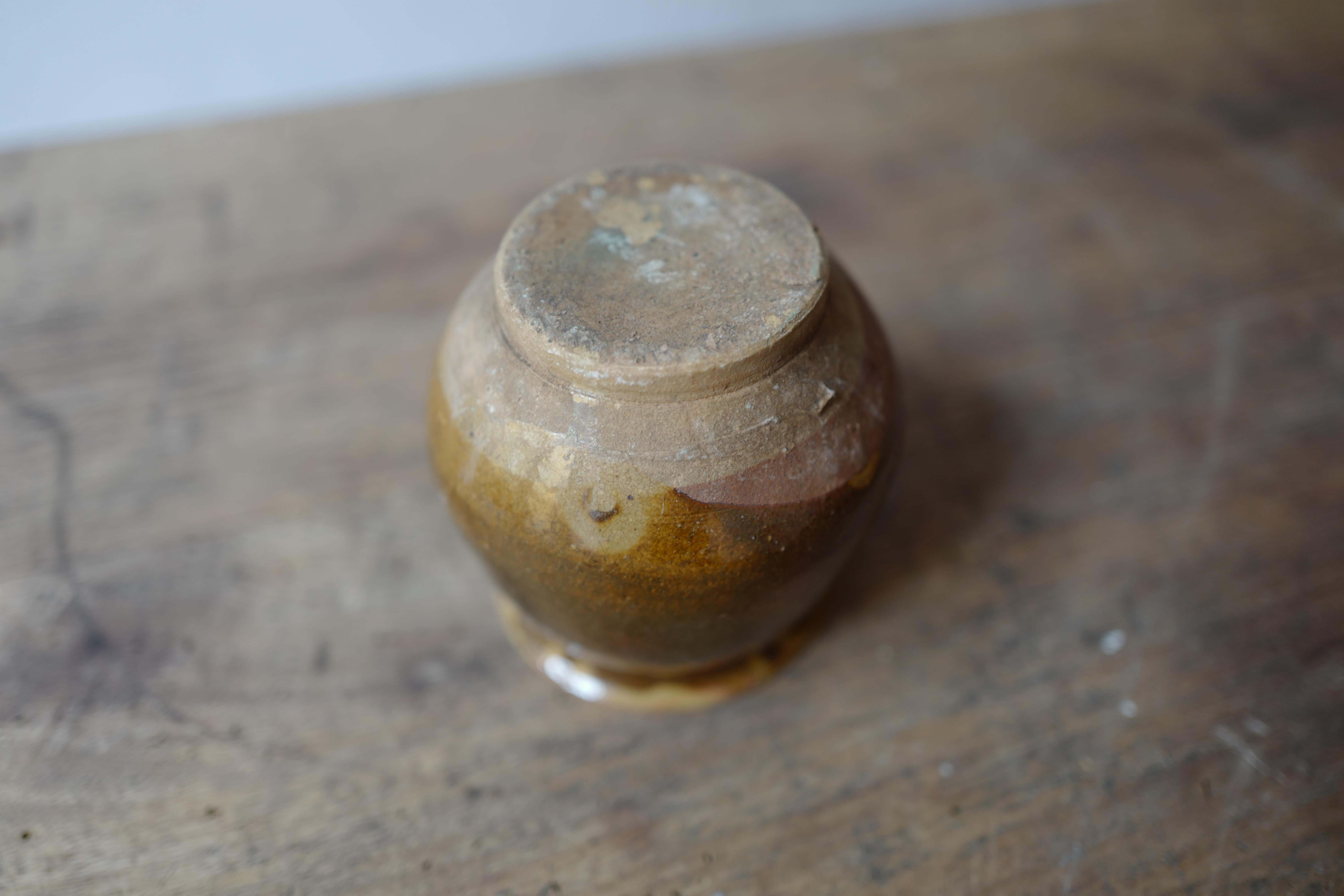 Add a touch of rustic elegance to your home with this Antique 19th Century French Provincial Honey Pot, featuring a stunning brown glaze and petite size. Handcrafted in France during the 1800s, this charming honey pot embodies the rustic charm of