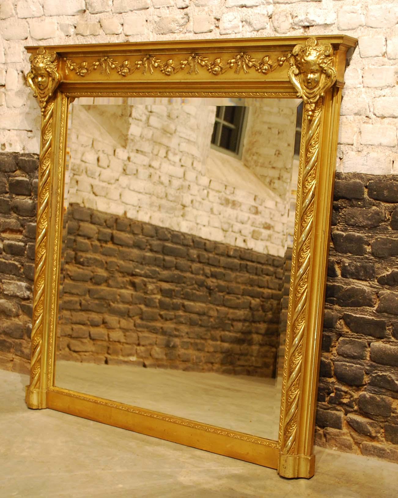 This is a beautiful antique French rectangular overmantle mirror that was made in Northern France, circa 1890. The piece has two bold gadrooned pillars with a frieze above decorated with garlands and tied ribbons flanked by cherub heads. The mirror