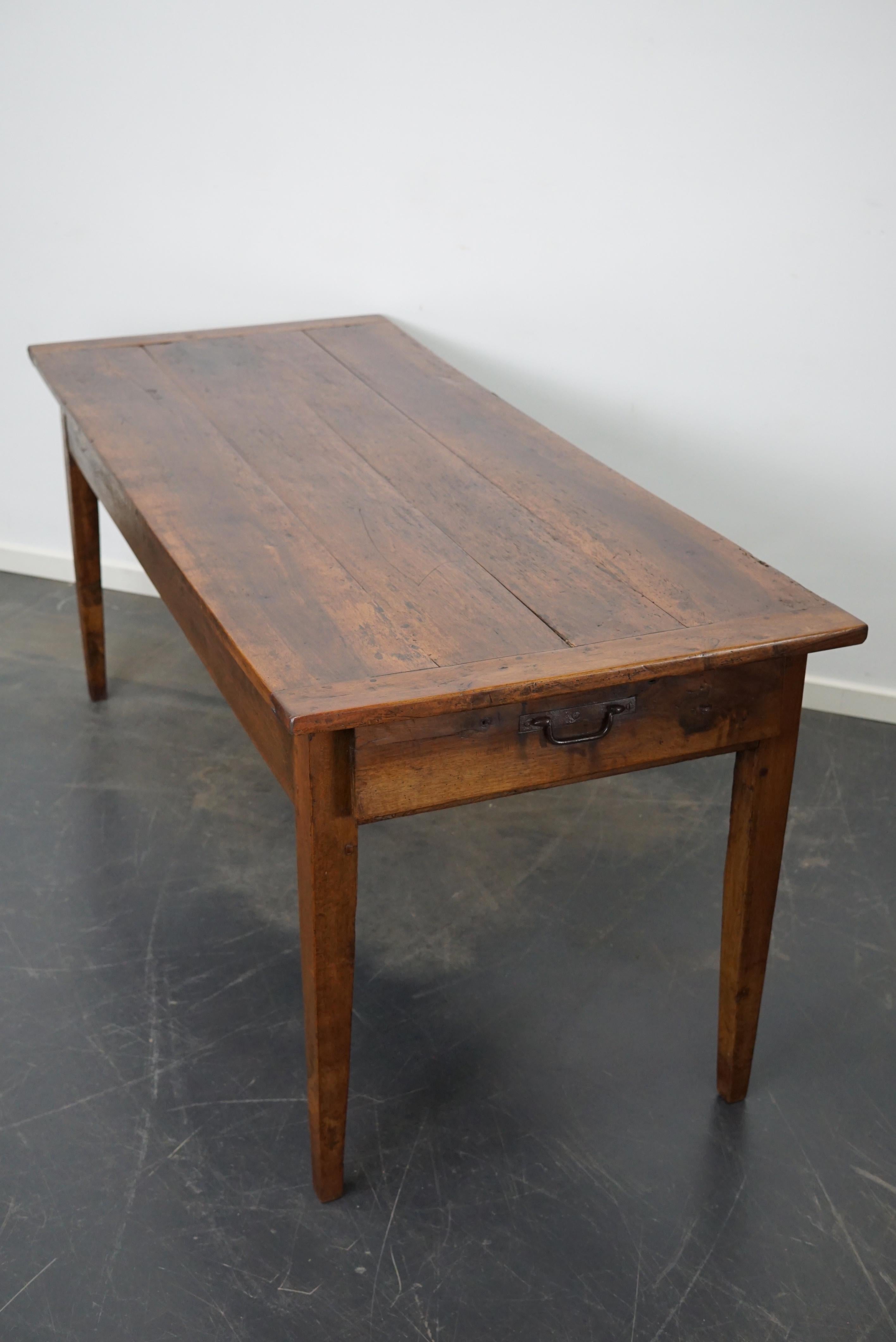 This elegant table was made in Southern France in the mid 19th century. It has a tabletop made from fruitwood. The table was made in solid fruitwood and chestnut with beautiful grain patterns. It has a very warm color and the table shows many marks