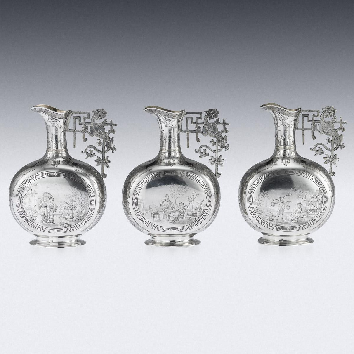 Antique early 19th century French exquisite and rare solid silver set of three dessert wine ewers in chinoiserie style, of Chinese inspired flask vase shape, standing on a spread-oval base and applied with an elaborate dragon and bamboo