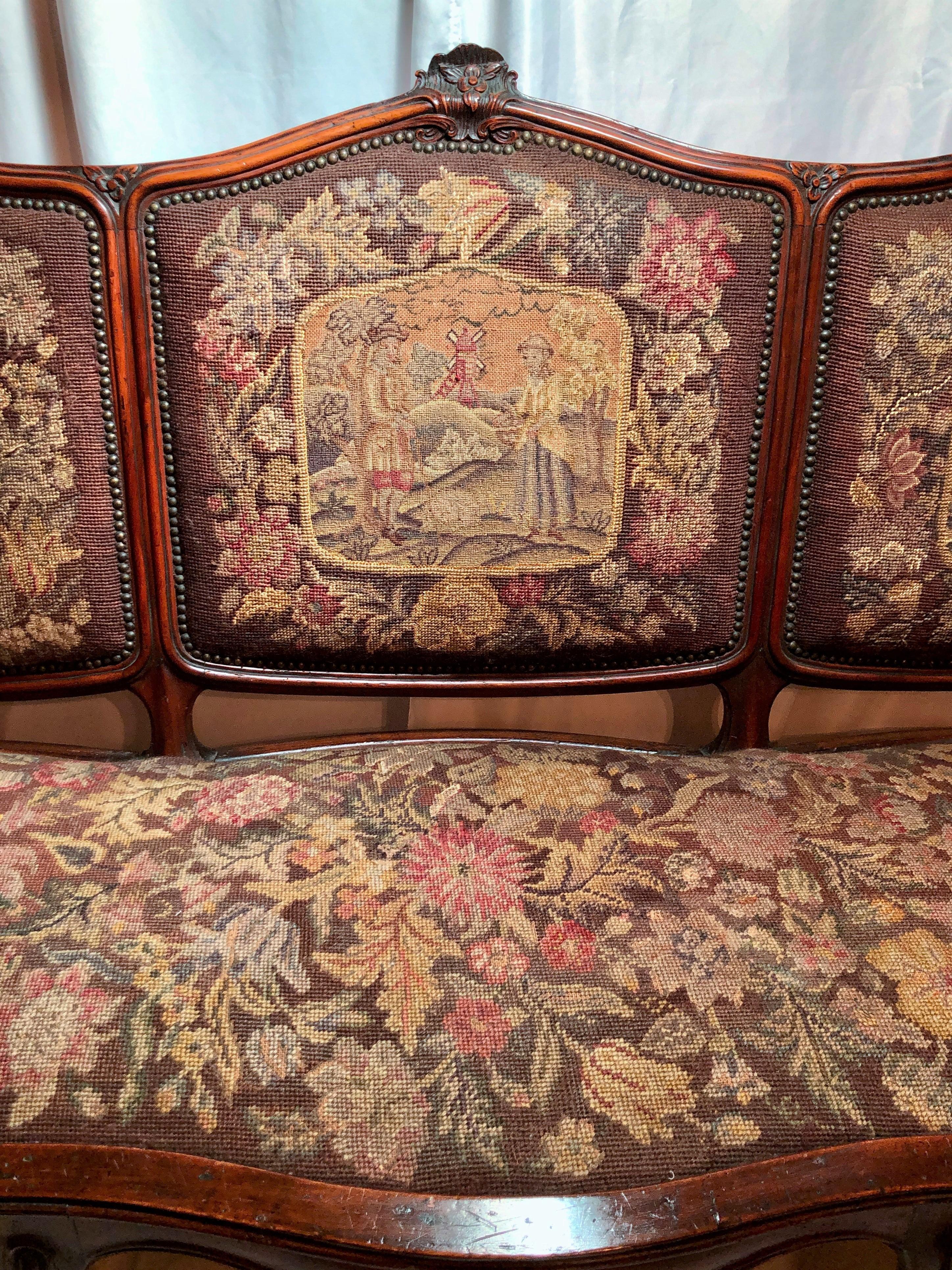 Antique late 19th century French walnut settee with original needlepoint and petit point.