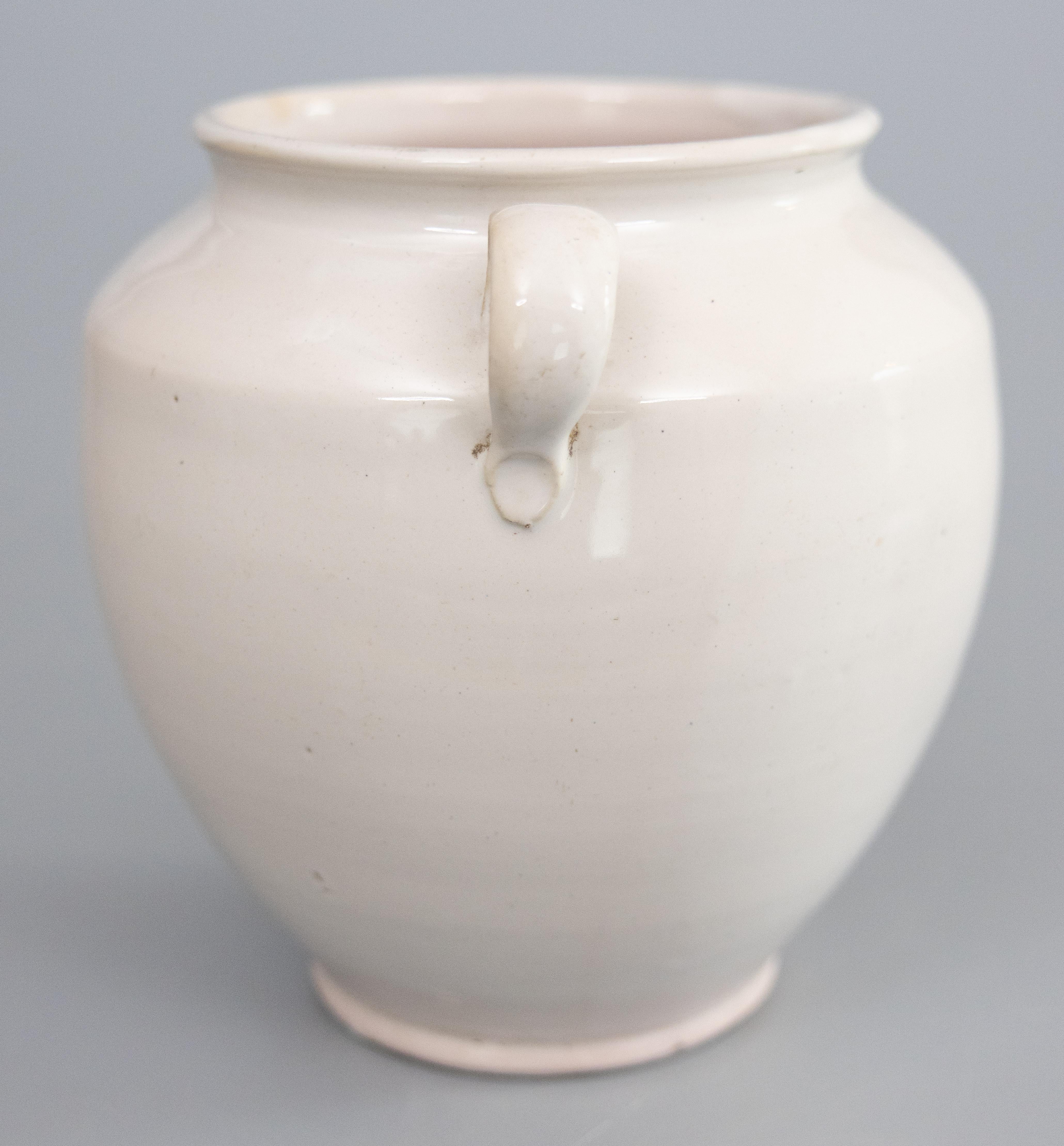A lovely antique 19th-Century French creamy white glazed confit pot or jar from Martres-Tolosane in South West France. This pot is full of character, hand thrown and glazed with two charming handles, known as 'ears.' These jars were used for storing