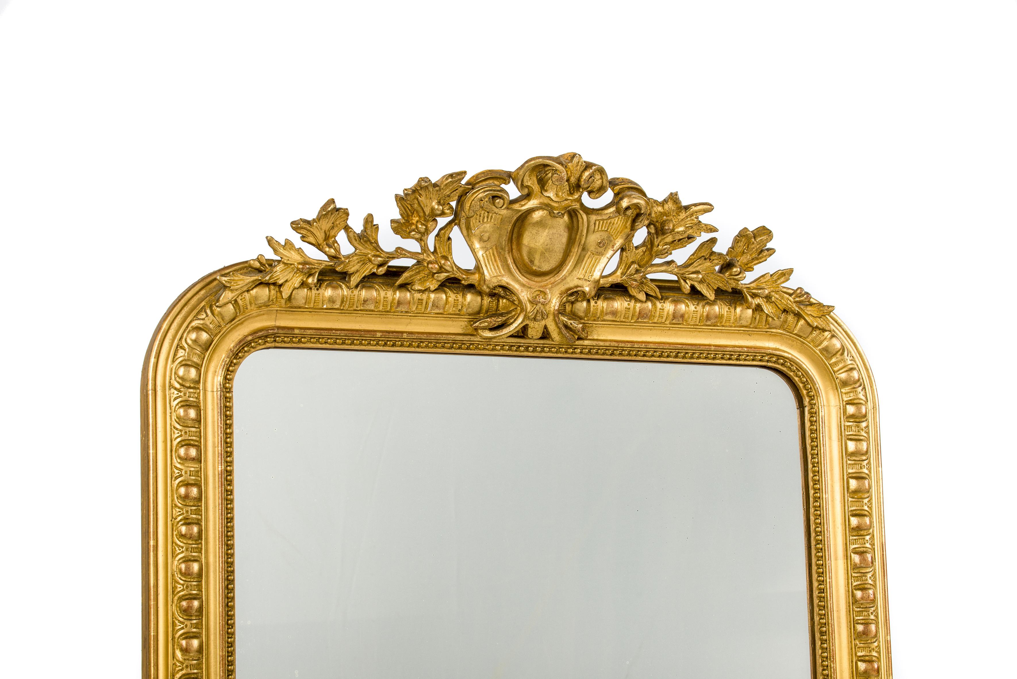This beautiful antique mirror was made in Southern France in the mid 19th century. It has the upper rounded corners that are typical for Louis Philippe mirrors. The mirror frame has a detailed gadrooned profile and a classic pearl beading surrounds