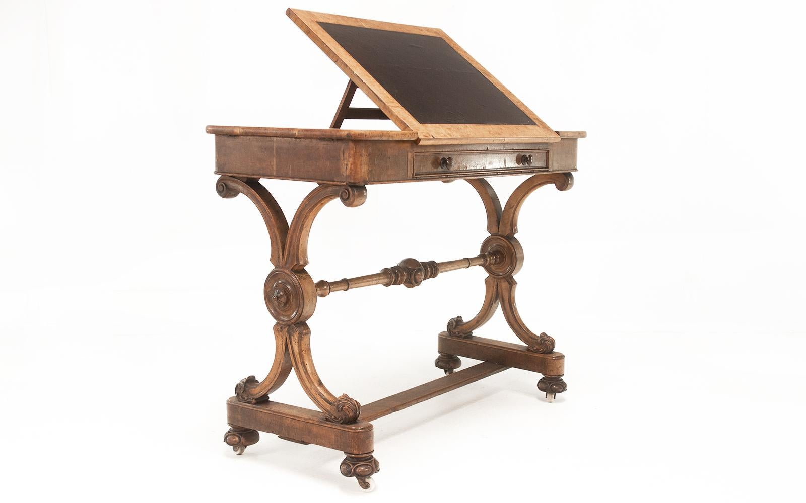 Architects table

Mid 19th century architects writing mahogany desk, the top with central leather inset panel rising on ratchet support, and two hinged end panels opening to satinwood fitted interior.

There is a single drawer to the front and