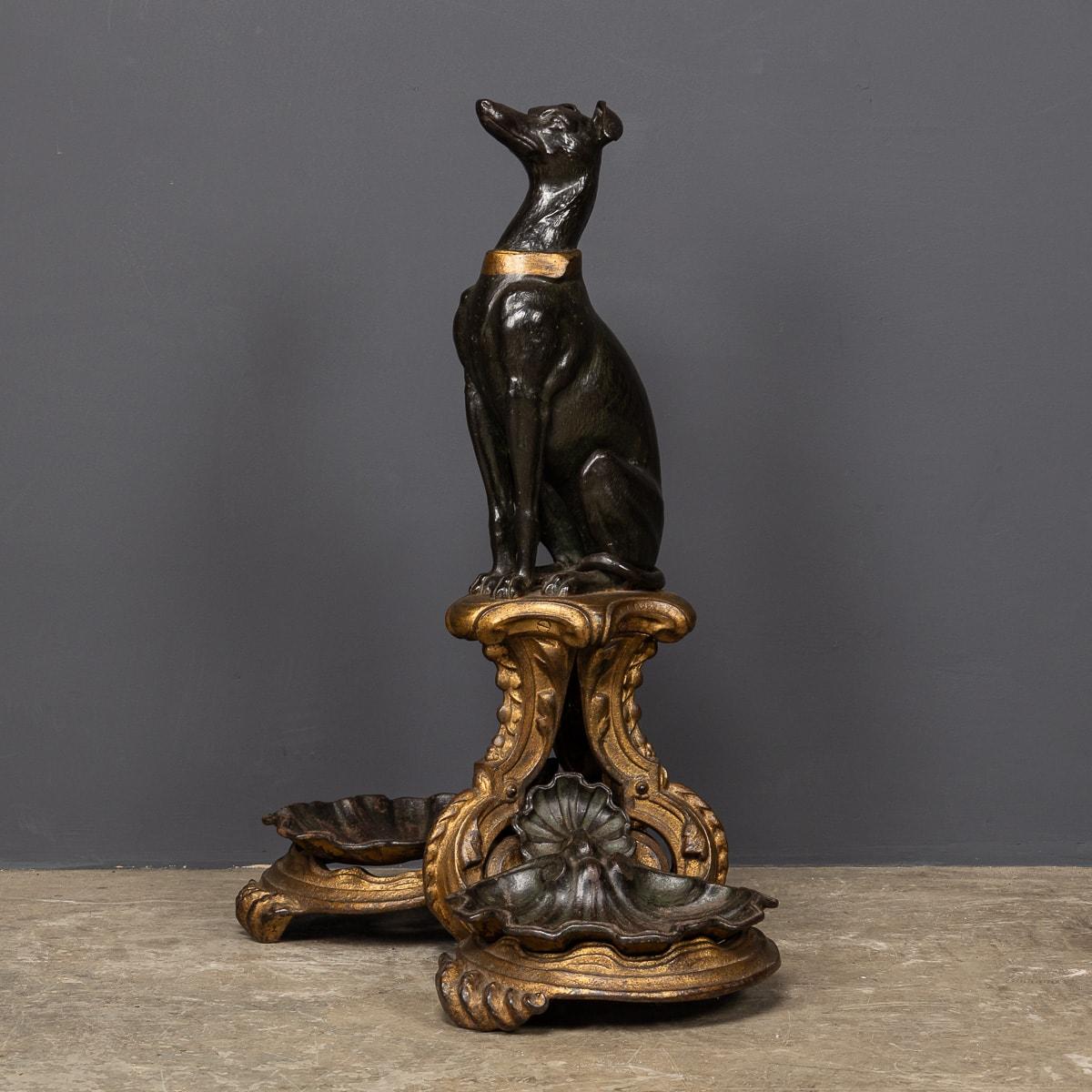 Ancienne canne en bronze géorgien du XIXe siècle représentant un gracieux lévrier assis sur un piédestal orné, flanqué de deux coquilles Saint-Jacques ornées de leur peinture noire et dorée d'origine. Cette pièce remarquable sert à la fois d'objet