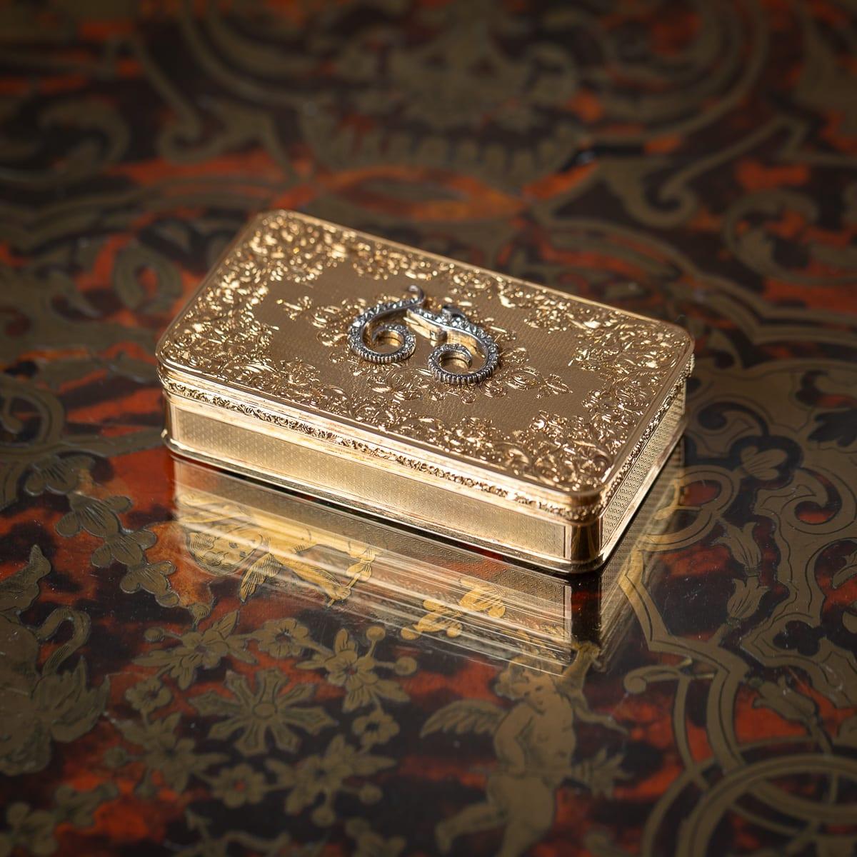 Antique 19th Century German 18K gold snuff box, rectangular in form. The lid is finely engraved with floral motifs and set with an initial L set with 30 diamonds, while the base also bears floral engraving. The sides are engine turned. The box is