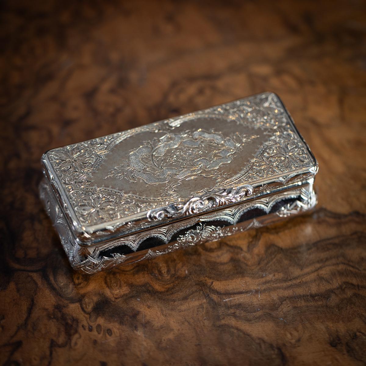 Ancienne tabatière allemande du 19e siècle en or massif 18 carats de forme rectangulaire en forme de coussin. Le couvercle est gravé de motifs floraux et de motifs géométriques diagonaux, et se termine par une pièce de pouce florale appliquée. En