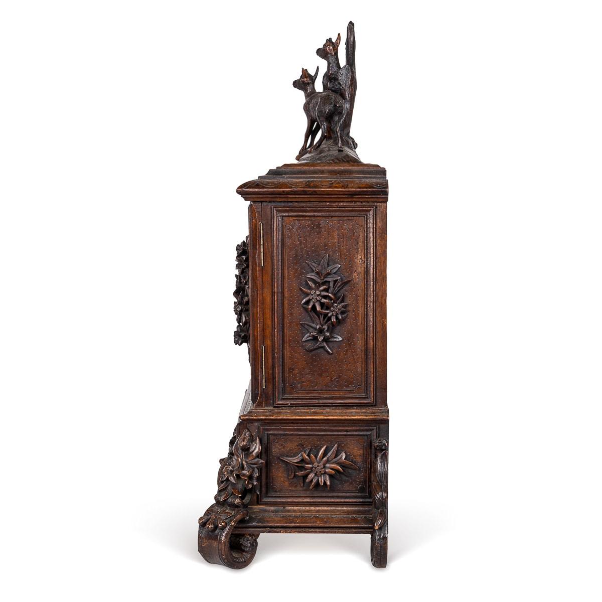 Antique late 19th Century German Black Forest fruitwood humidor. Its top intricately carved with a scene depicting a deer and its young. Below, two doors adorned with molded flowers and leaves lead to a compartmentalised interior, revealing hinged