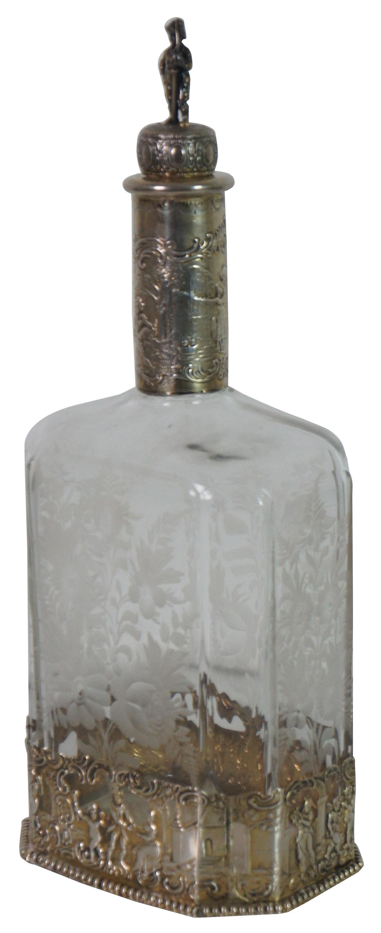 Antica bottiglia decanter tedesca vittoriana con tappo figurato attribuita a Jakob Storck & Sinsheimer. Realizzato in argento 800 e vetro inciso, presenta una scena di corteggiamento in stile barocco/rococò con figure e angeli che suonano trombe e