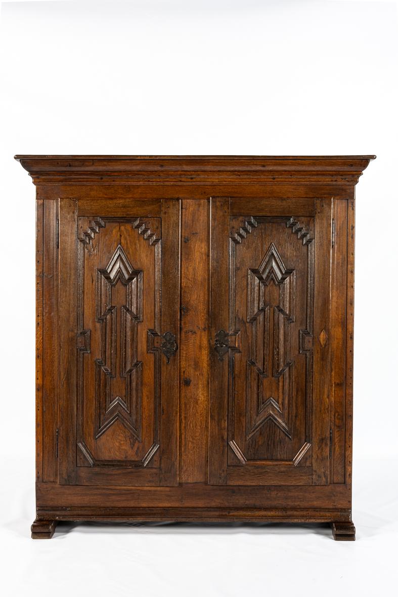 This rare spitsverkropte lijstenkast (stepped-molding cupboard) from North Rhine-Westphalia reflects the character and craftsmanship of mid-19th century rural Germany. Made entirely of solid oak, the piece has developed a warm glow and rich patina