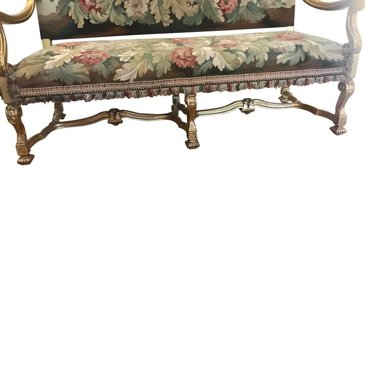 A collectible piece from bygone days, featuring the finest craftsmanship, materials, and design elements of its given era. Elegant and ornate, this stunning settee features a hand-carved giltwood frame and tapestry-style upholstery. Made in France