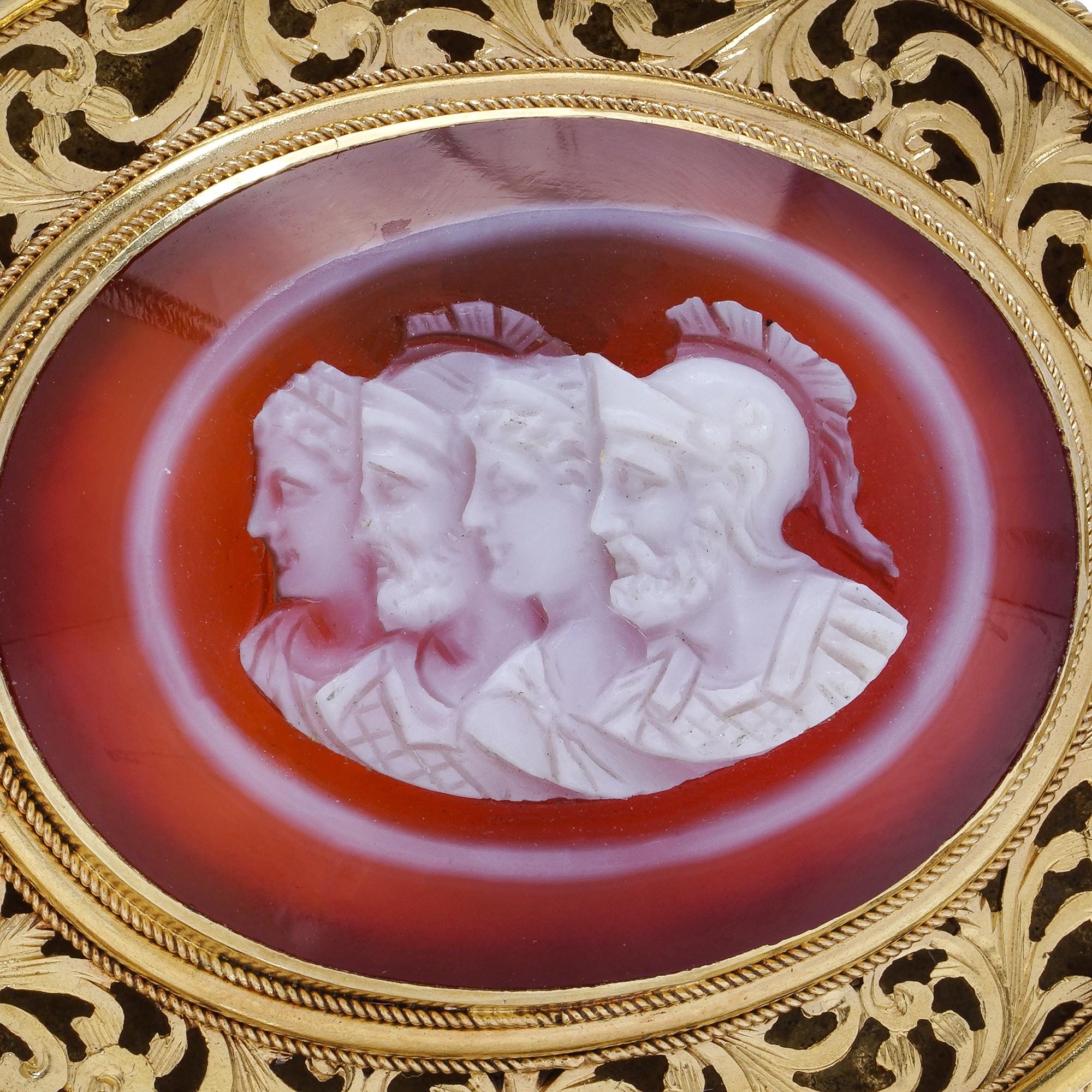 Antique 19th century 21kt gold and carved banded agate cameo brooch. 
Made in circa 1850s 0 1870s. 

Cameo Design: The central stone is a multi-layered cameo, carved from agate. It features three finely detailed figures, referencing historical or