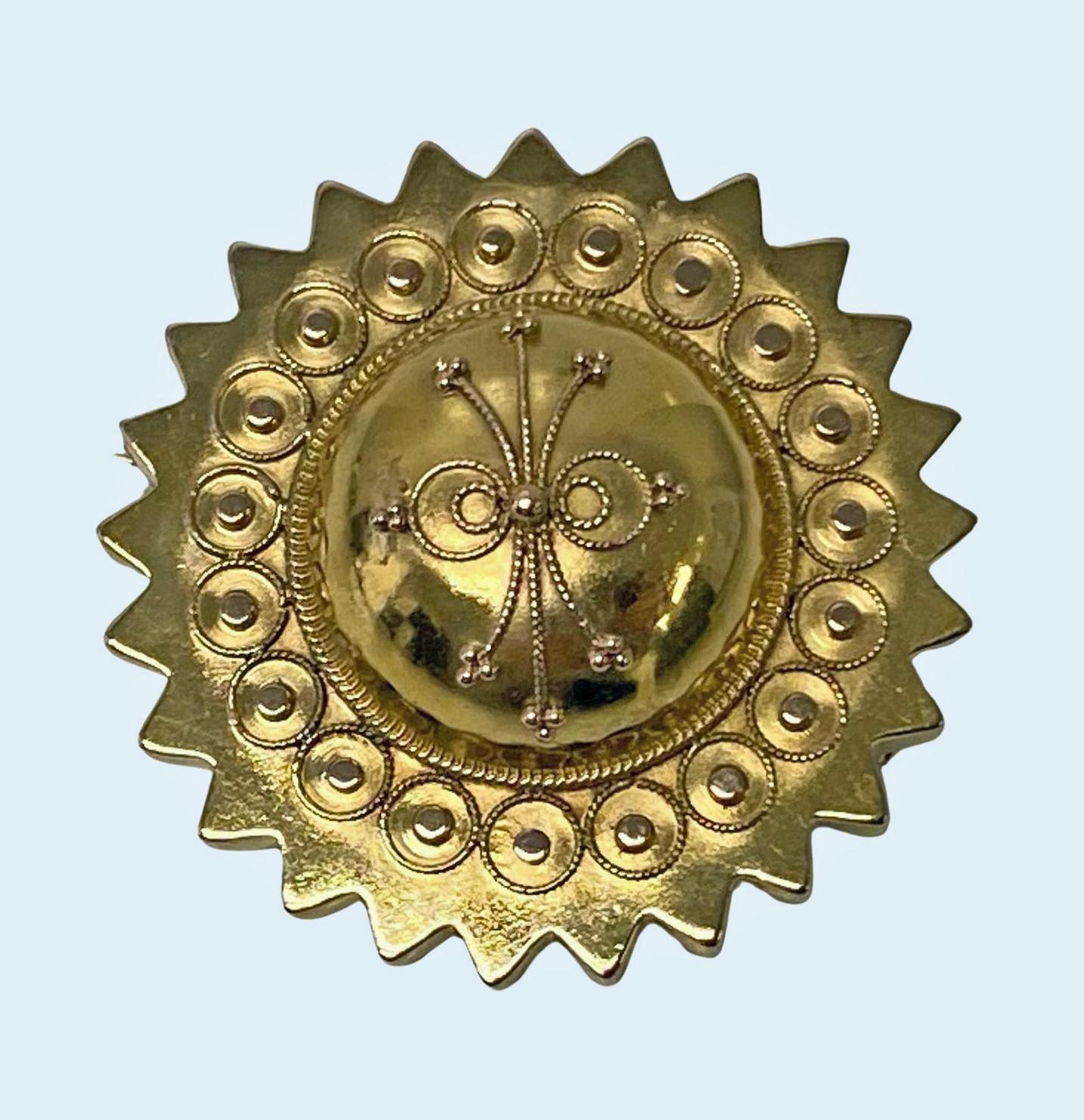 Antique Victorian 15K gold brooch, English C.1870. The brooch centering a dome with estruscan decoration surround of bead rondelle circlets and outer star border. Locket to reverse. Later safety catch fitment. Acid tested as 15K gold. 35mm Diameter,