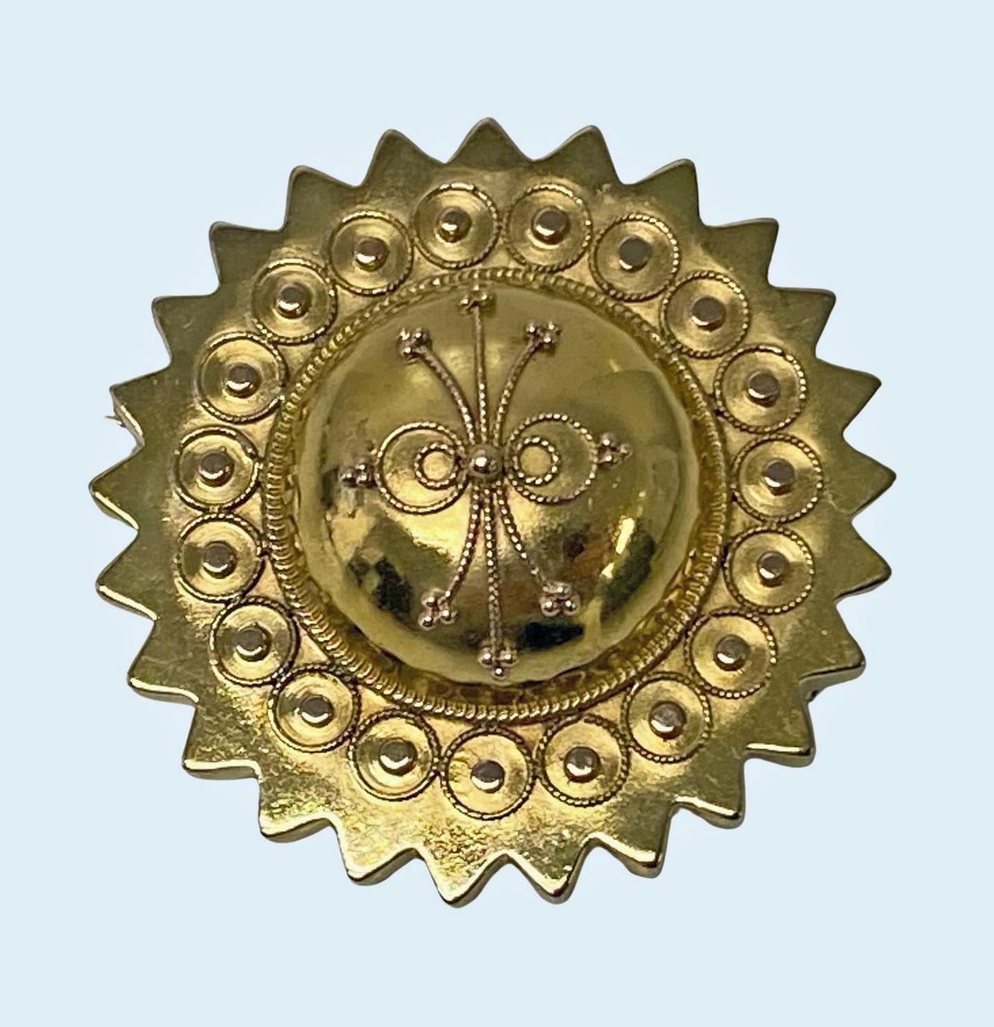 Antique Victorian 15K gold brooch, English C.1870. The brooch centering a dome with etruscan decoration surround of bead rhondelle circlets and outer star border. Locket to reverse. Later safety catch fitment. Acid tested as 15K gold. 35mm Diameter,
