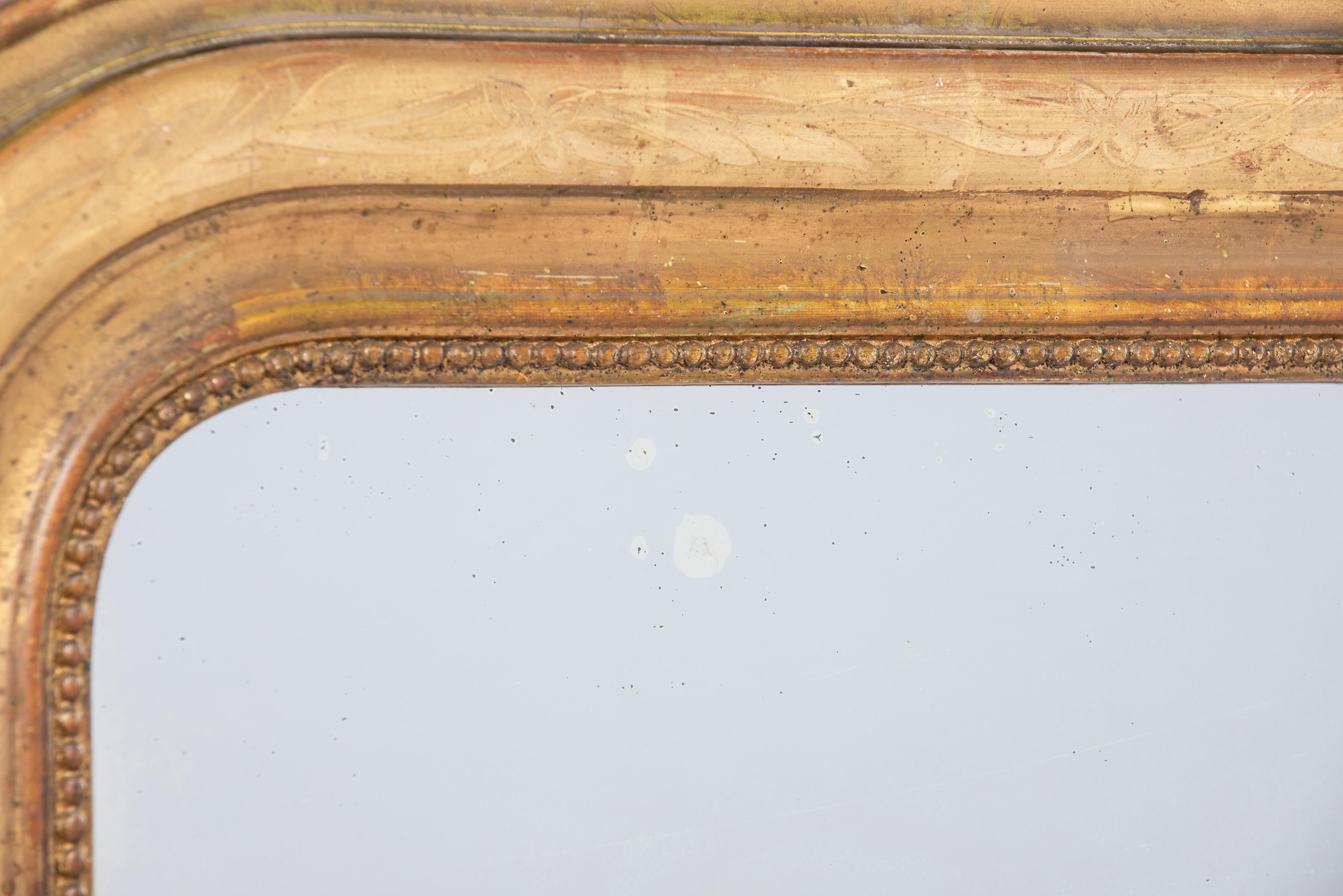 Il s'agit d'un élégant miroir ancien qui a été fabriqué au milieu de la France à la fin du 19e siècle, en 1881. Il présente les angles supérieurs arrondis typiques du style Louis Philippe. Le miroir a un cadre en pin massif qui a été lissé avec du