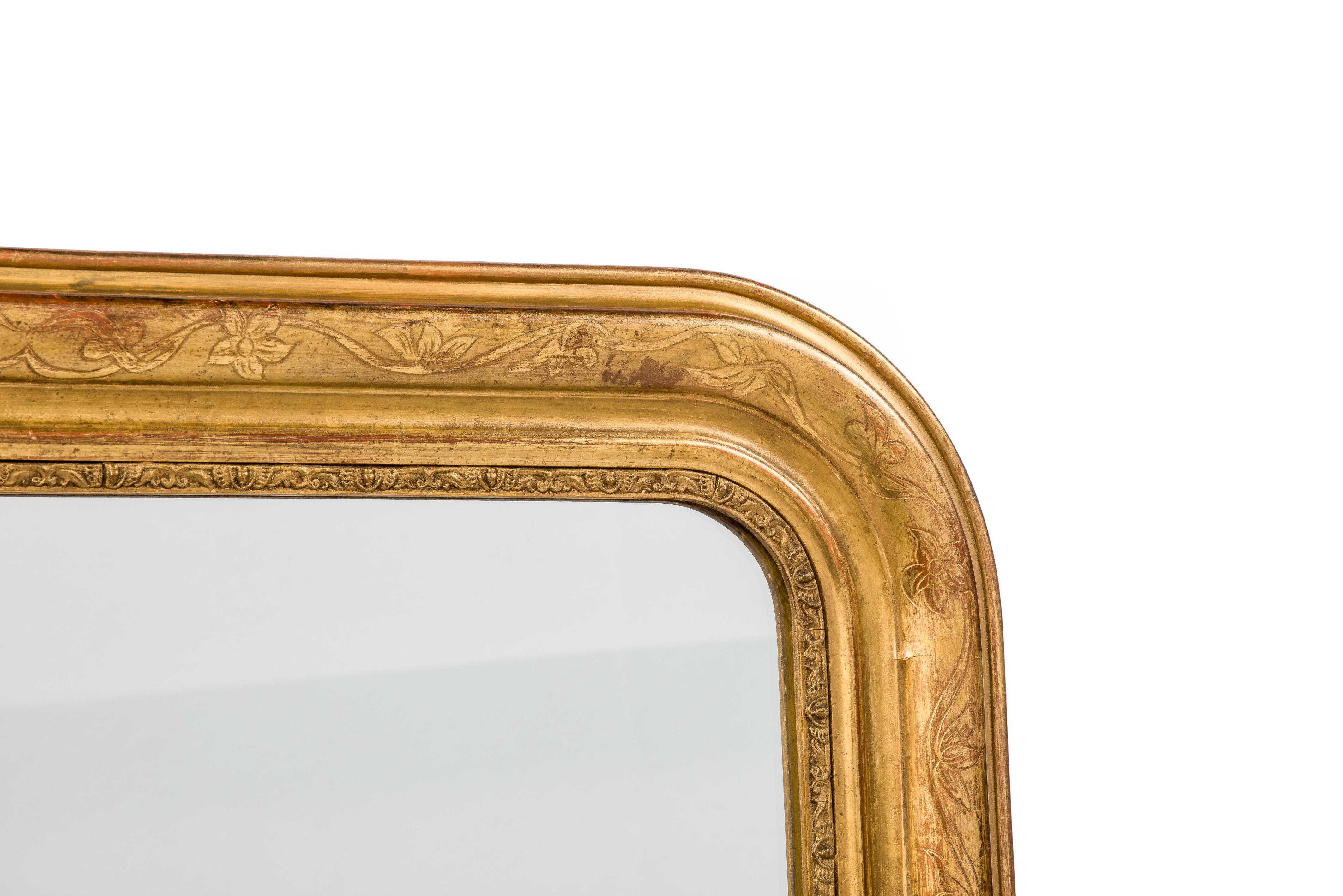 This is a beautiful partially gold leaf gilt and partially gold painted Louis Philippe mirror that was made in France at the end of the 19th century. It features the upper rounded corners typical for French Louis Philippe mirrors. The frame is