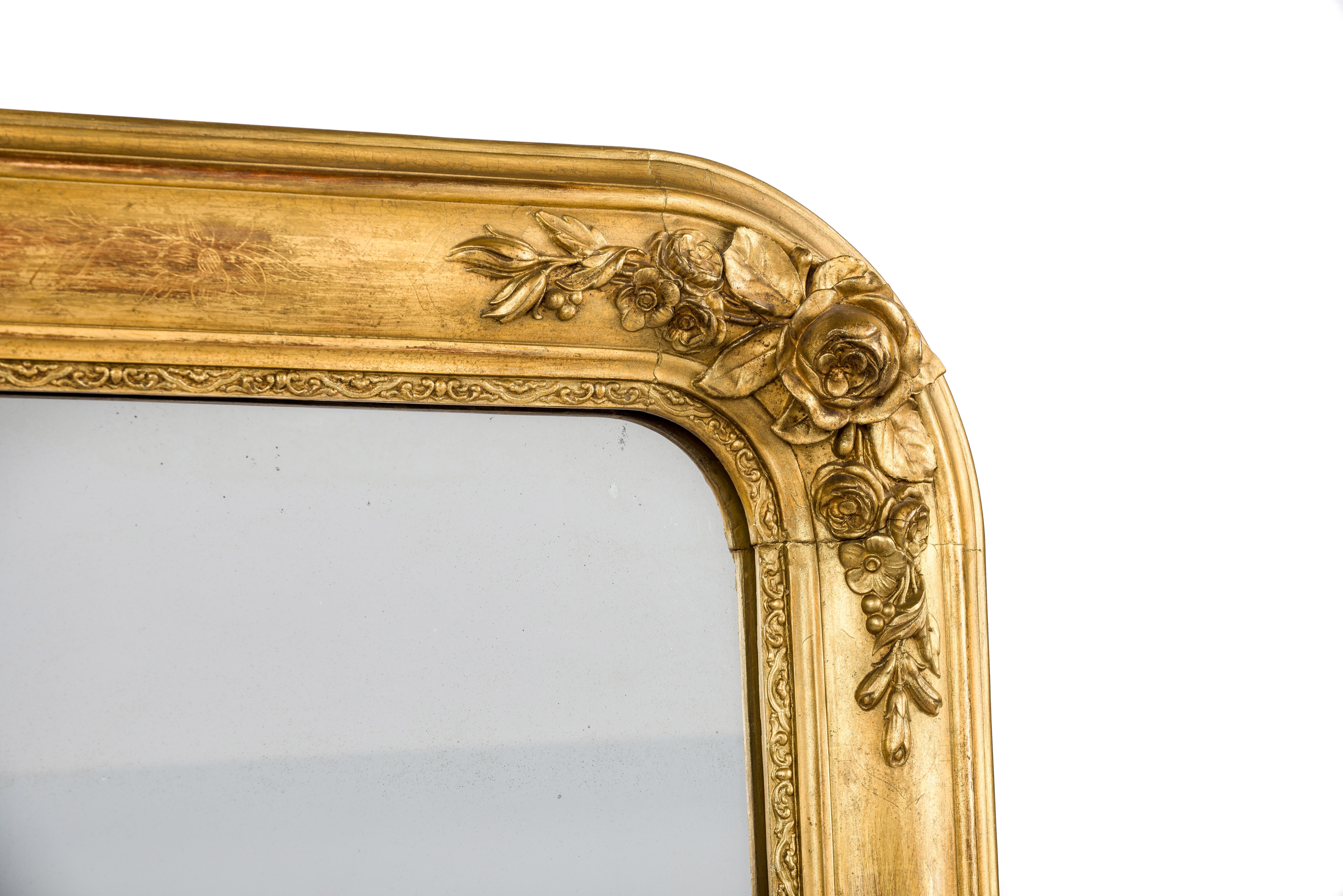 This beautiful antique mirror was made in France in the mid-19th century. It features the upper rounded corners typical for the Louis Philippe style. The mirror has a solid pine frame that was smoothened with gesso. The most elevated part was