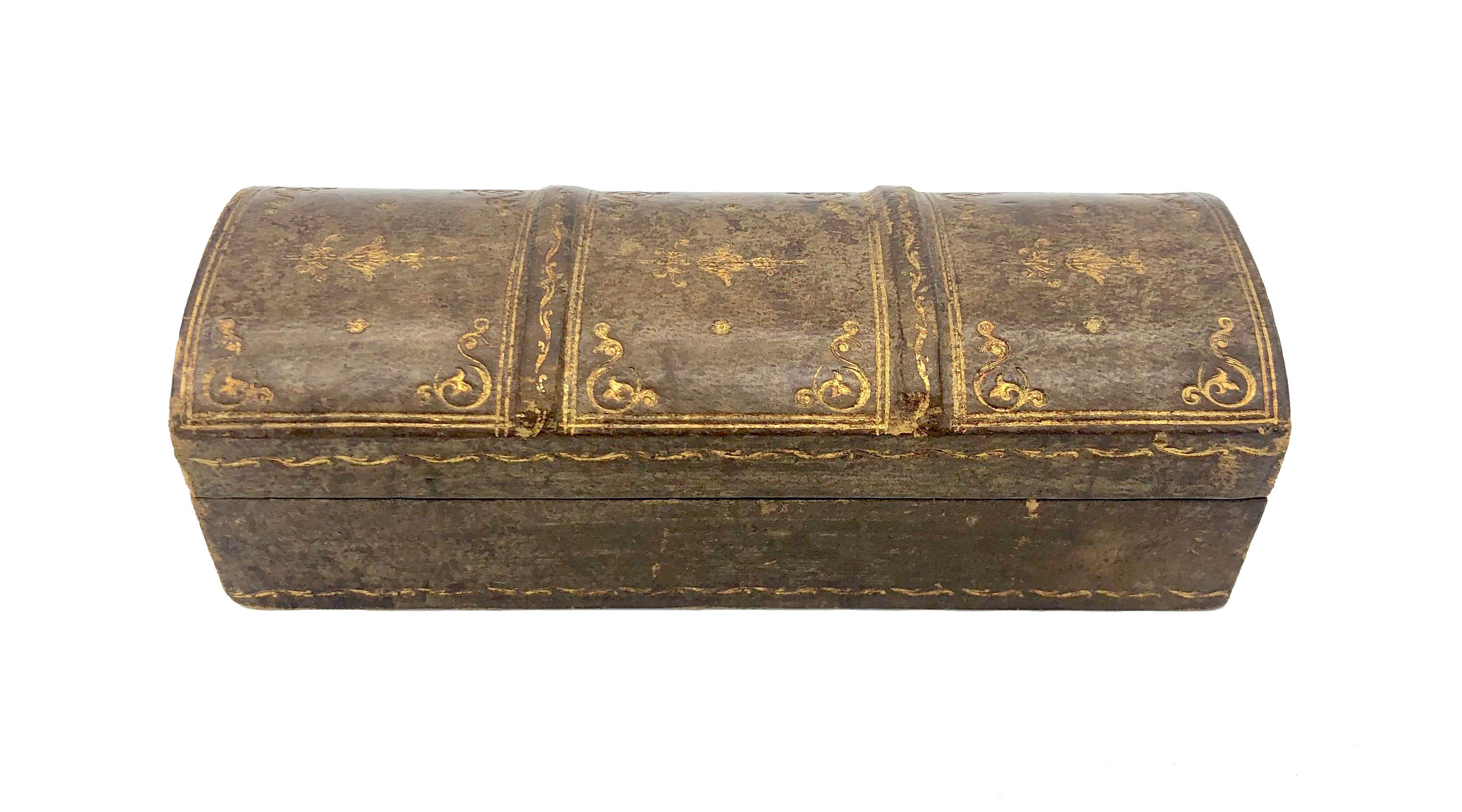 This elegant box was handcrafted in the last 15 years of the ninetennth century. It is made out of leather, wood and fabric. The four sloping compatrments suggest that this box was used for stamps. This lovely object with it's fine patina resembles