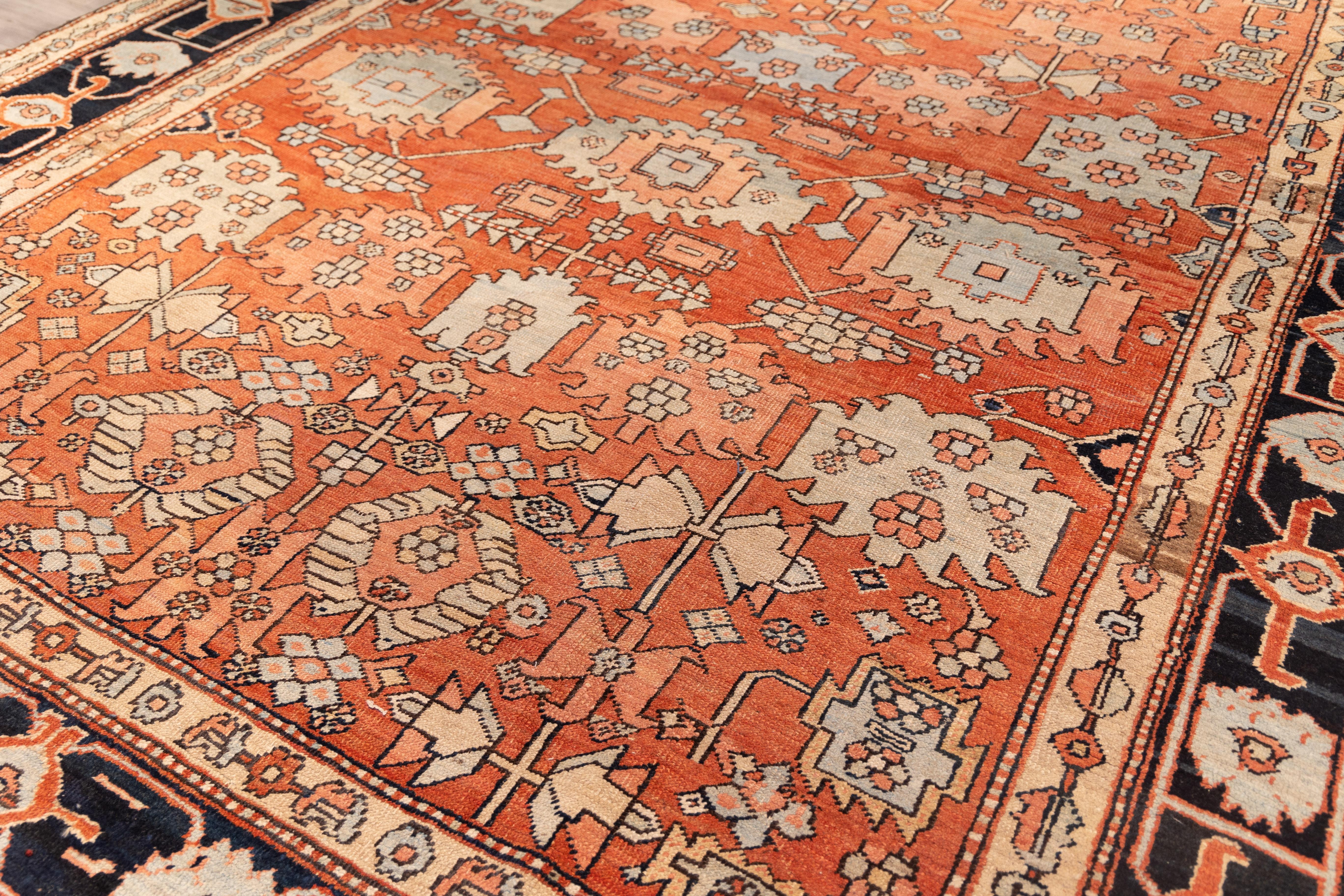 Beatigul tribal Gorovan from late 19th century  featuring a bold layout with a abrashed coral field filled with large, blocky floral and geometric shapes in ivory and soft teal. The navy border adds strong contrast, decorated with abstract flowers
