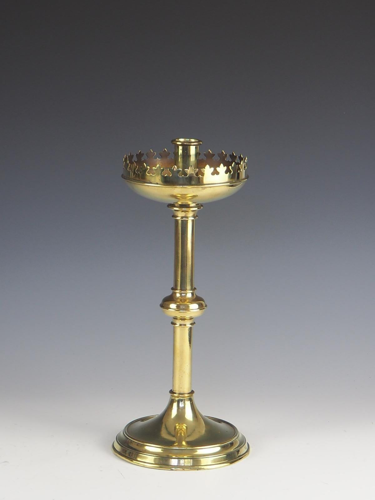 Decorative late 19th century Gothic brass candlestick. The candlestick consist of a rimmed edge with a drip pan.

Leads down to a column supported by a stepped circular base.
