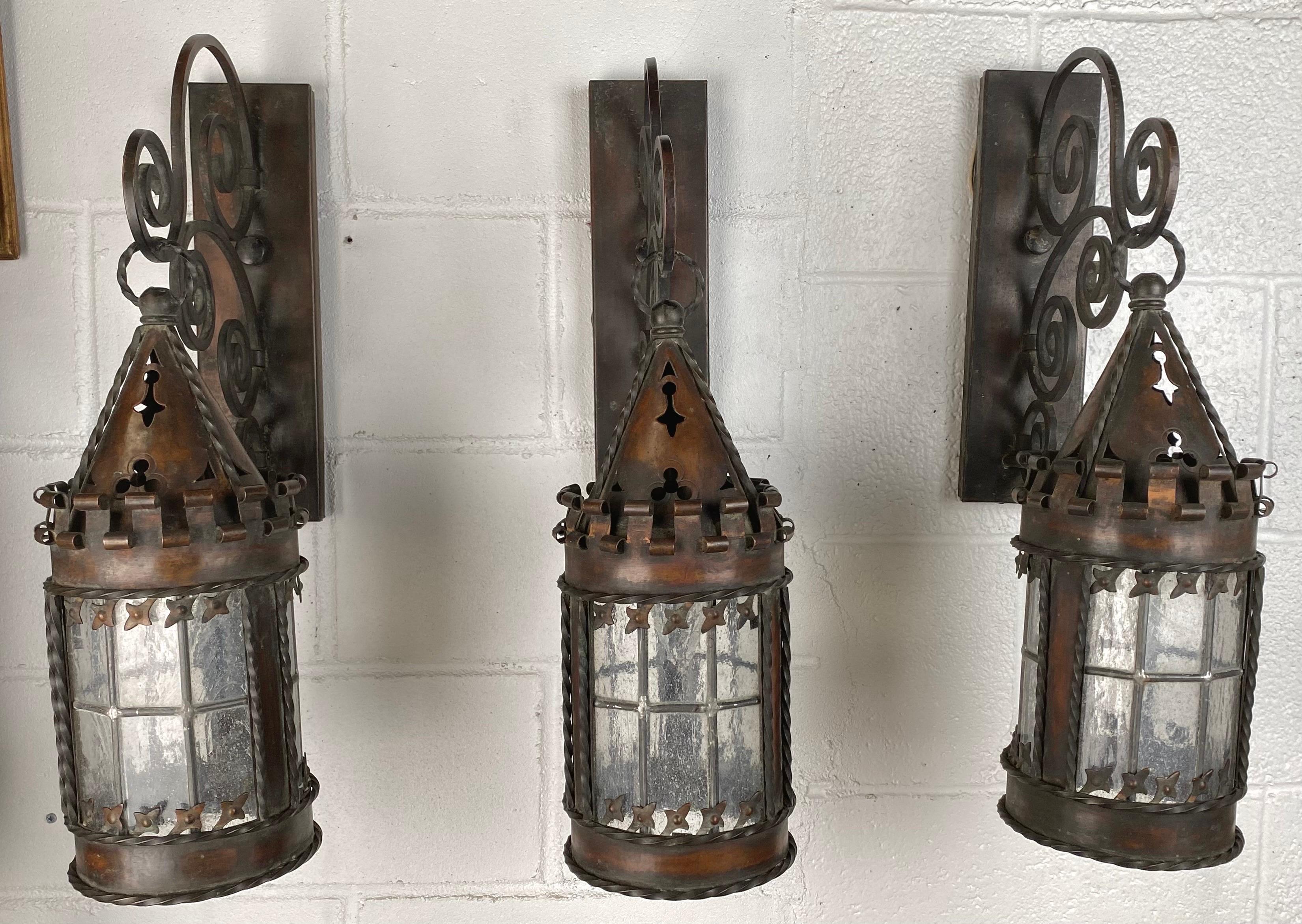 
A  timeless  set of three exquisite 19th Century Gothic Spanish Revival hand-forged wrought iron  wall sconces, a captivating trio that seamlessly melds craftsmanship and artistry. Perfect for both exterior and interior spaces, these distinguished