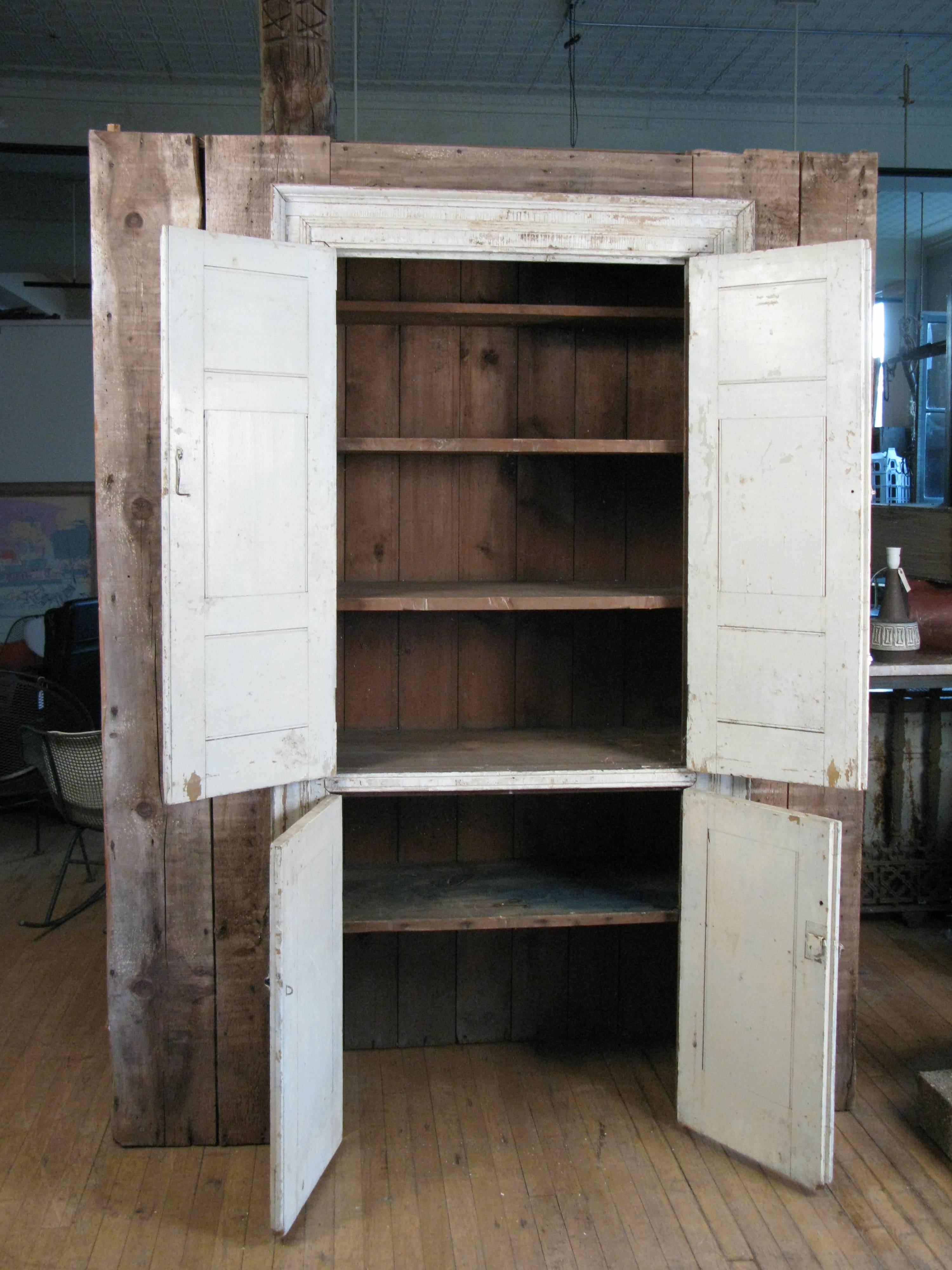 A very unique 19th century Greek Revival wall cupboard, originally built into a Greek revival house. it was carefully removed so the cupboard is intact including the painted doors with molding surround.