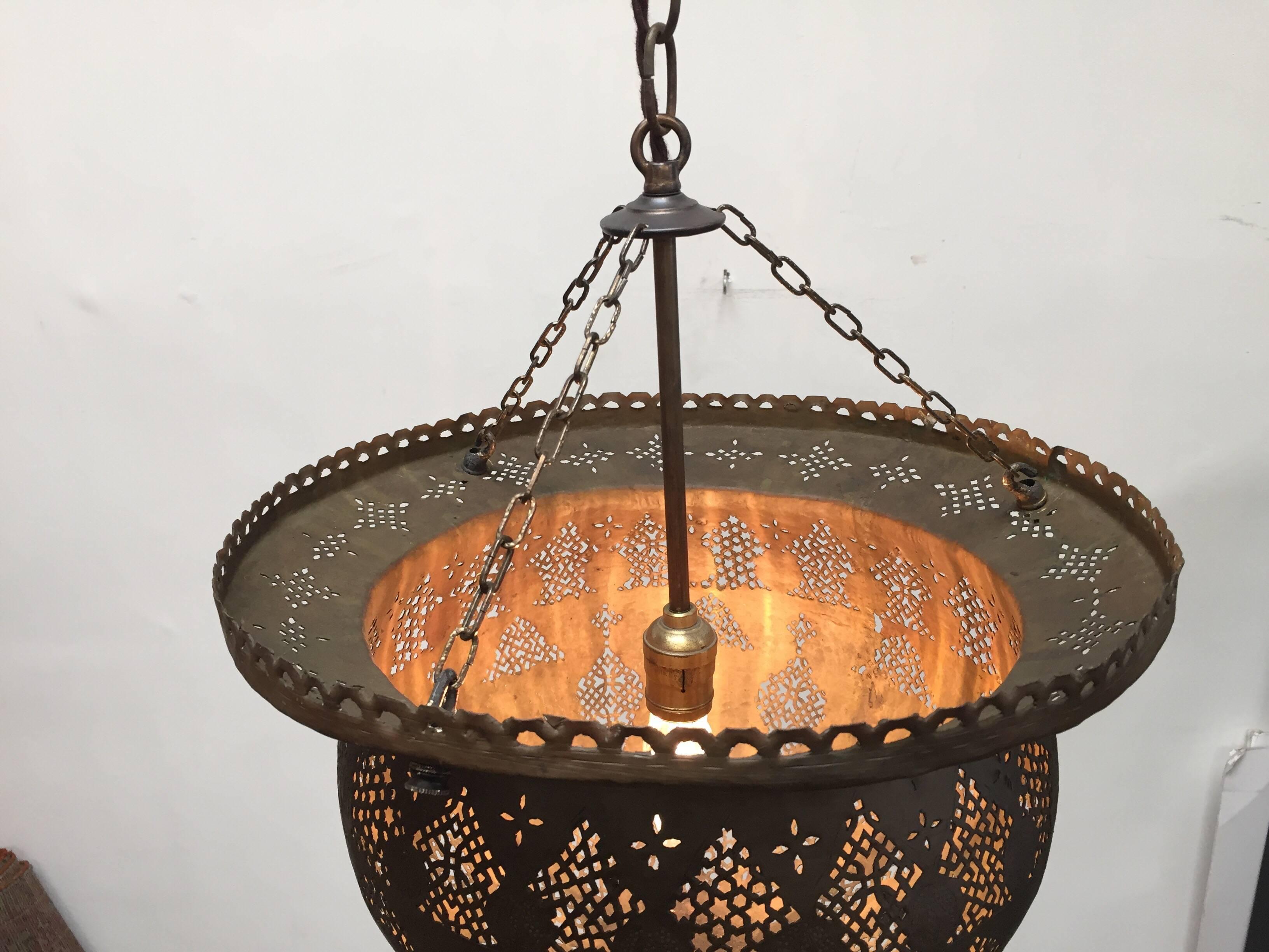 Antique 19th century handcrafted Moorish pierced brass Turkish Ottoman pendant chandelier.
The brass hanging lamp with open work design is delicately hand-hammered and chiseled with Arabic Kufic calligraphy writing and fine filigree floral patterns