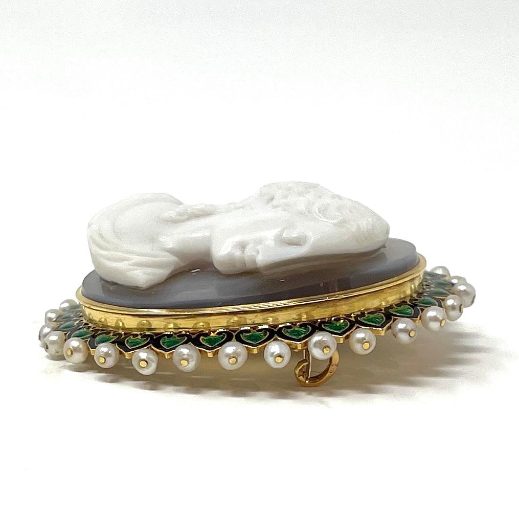 An elegant Victorian lady carved in high relief of banded chalcedony is mounted in a lovely green French enamel and natural pearl setting.

The pin components have French hallmarks and maker's marks. The pin measures 2 1/4' high, 1 3/4