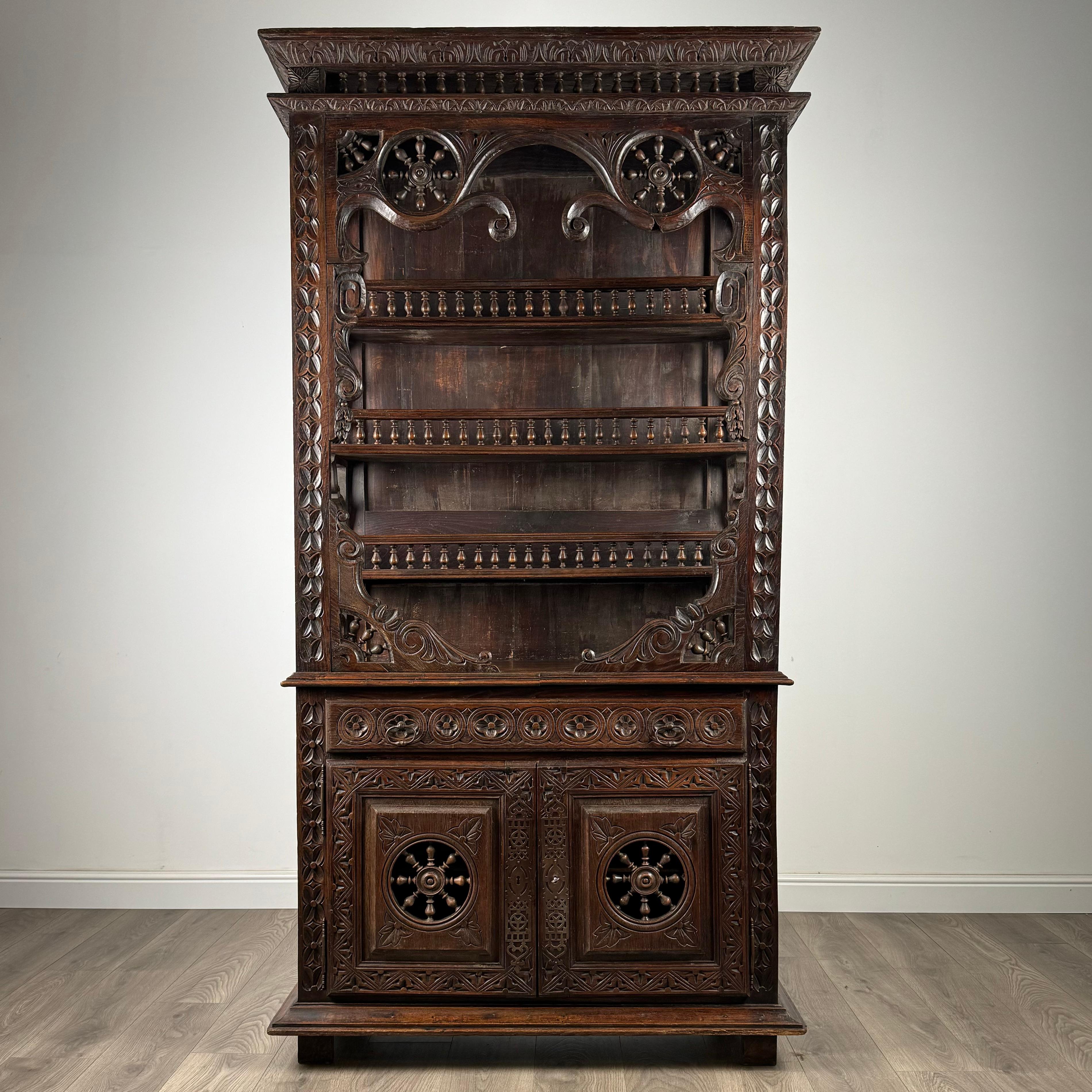 Step into a realm of exquisite craftsmanship with this remarkable 19th Century chestnut cabinet, a testament to the mastery of intricate carving and timeless design. Boasting a heavily carved exterior, this cabinet stands as a true work of art,