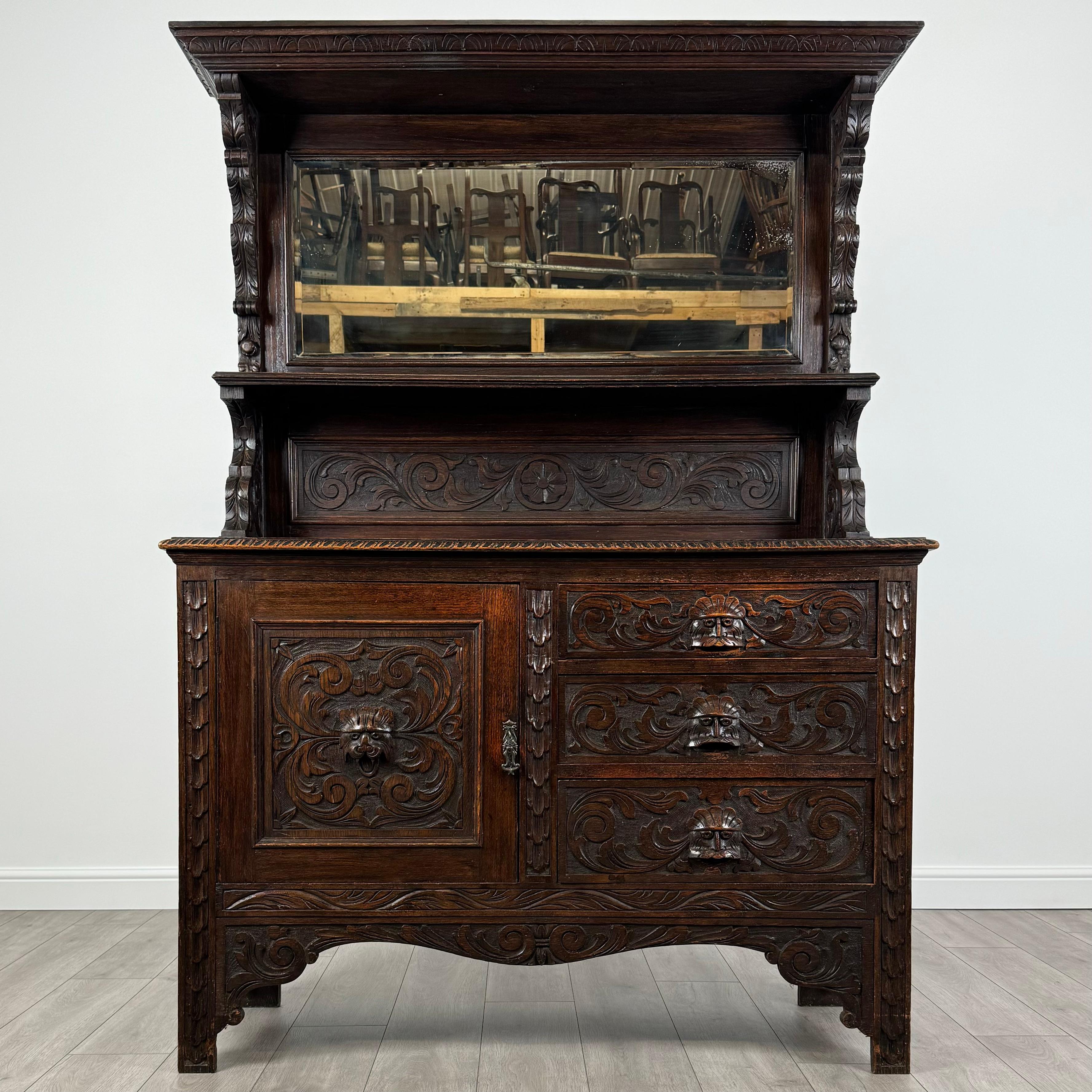 This stunning 19th-century mirror back sideboard is a masterpiece of craftsmanship, featuring intricate carvings and timeless elegance. Made from oak, it exudes character and charm with its finely detailed design. 
The upper section boasts a