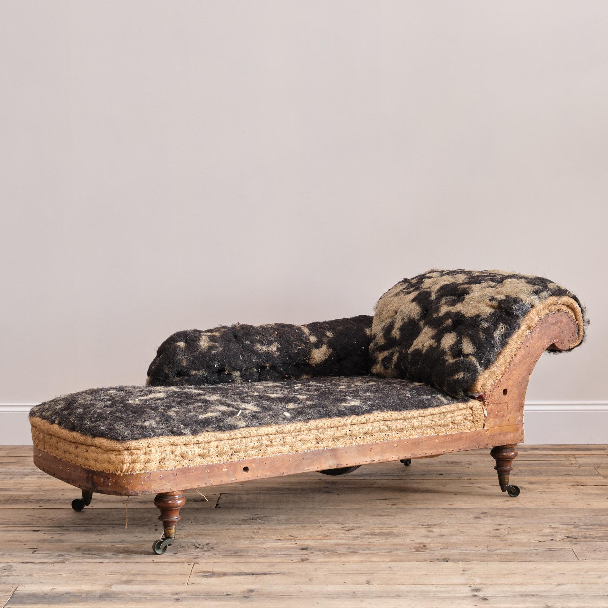 A 19th century chaise lounge by esteemed London maker Howard & Sons. This Chaise lounge dates back to the mid 19th century c1860. Its raised on turned walnut legs with the original Cope & Collinson brass casters. Structurally in good solid condition