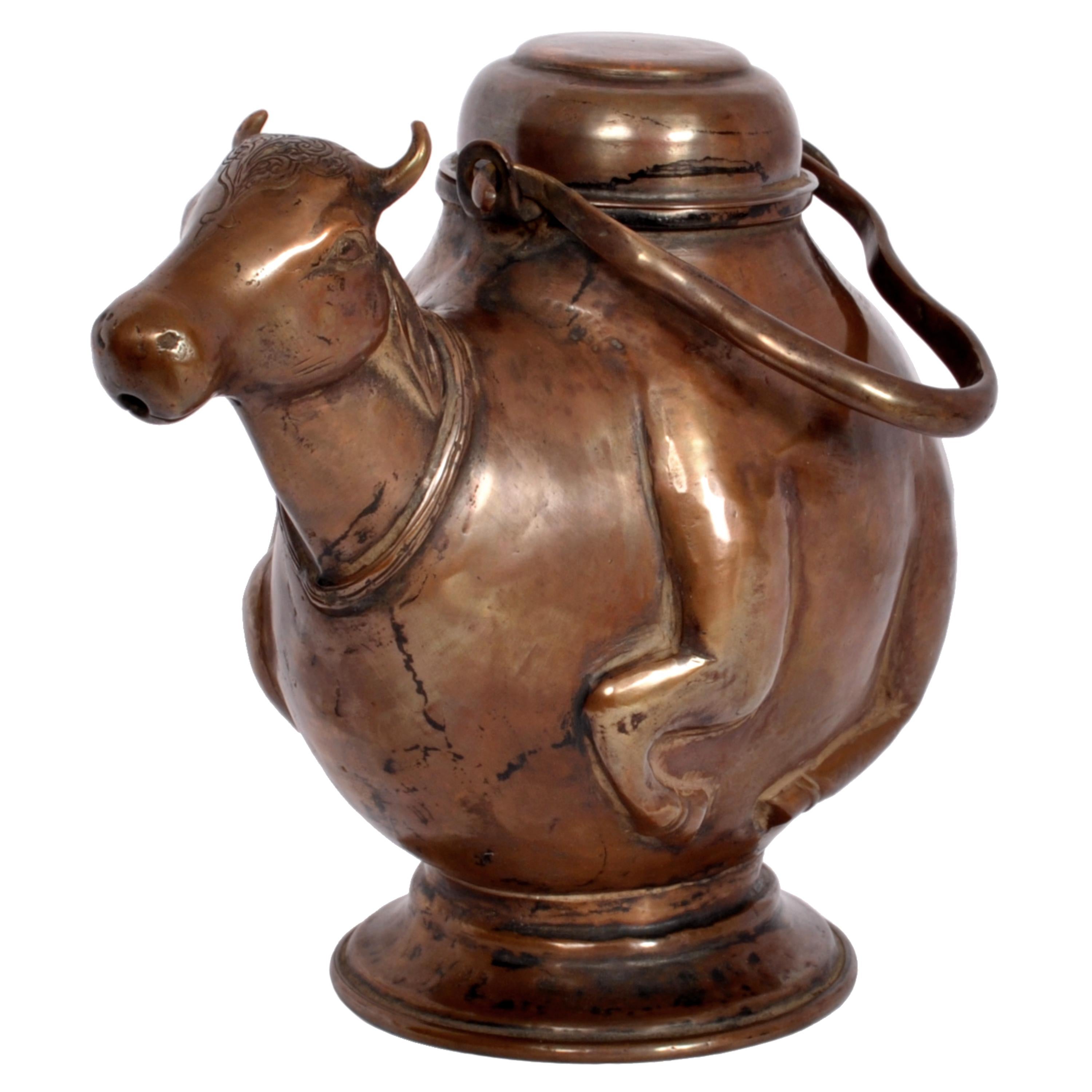 An antique Indian Hindu copper Nandi (bull) lidded and handled water vessel, circa 1800.
In the Hindu faith & culture of India the bull is a sacred animal, the term Nandi means 