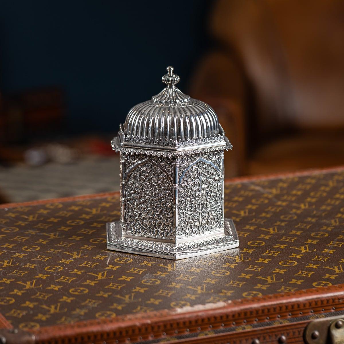 Antique 19th Century Indian (Kutch) solid silver tea caddy, shaped like a small Hindu courtyard temple. Hexagonal with a stepped foot, it is richly chased with floral sprays and scrolling vines on a finely matted ground. The hinged, domed, and