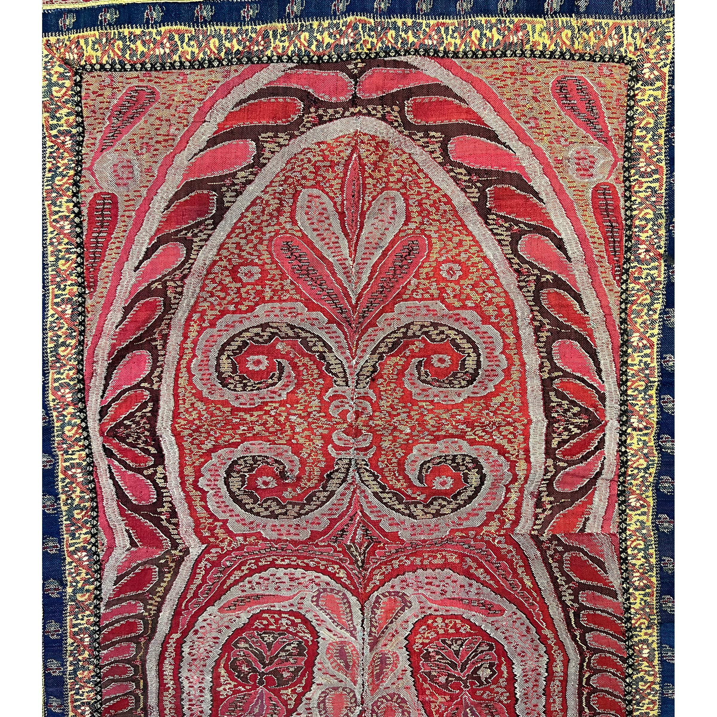 Red Indian Textile Runner, this runner features a beautiful Boteh design in shades of red, adorned with metal fringes that gracefully sway with movement, adding a sense of movement and fluidity to the piece, this piece dates back to the 19th