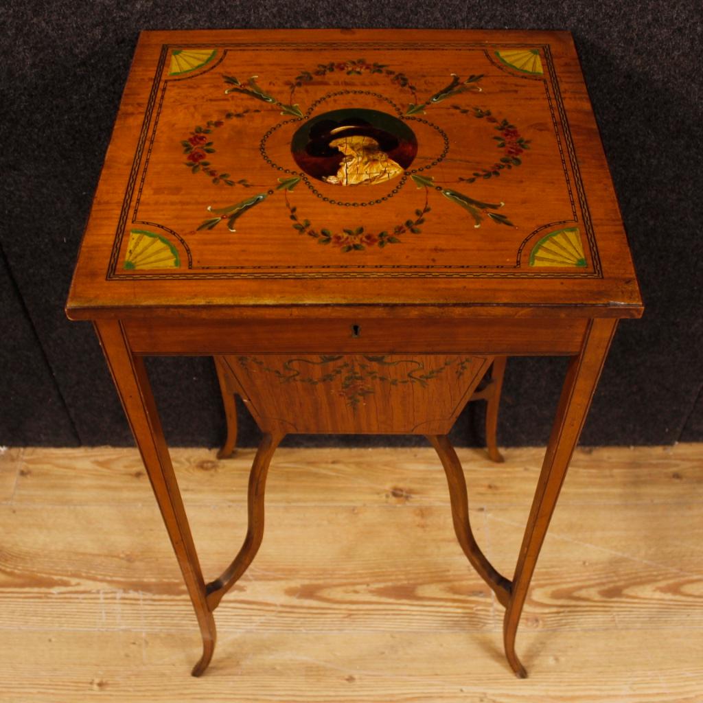 English sewing table from the late 19th century. Mobile inlaid in various essences precious and painted on the upper floor with a portrait of a woman (see photo), of great elegance. Coffee table with openable top complete with various internal