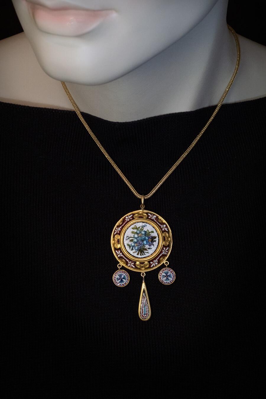 Italian, circa 1850s-1860s, probably made at Vatican workshops.
The pendant is crafted in 18K gold. It is designed in Etruscan revival style, fashionable in the mid 19th century, and embellished with fine micro mosaics of floral and berry