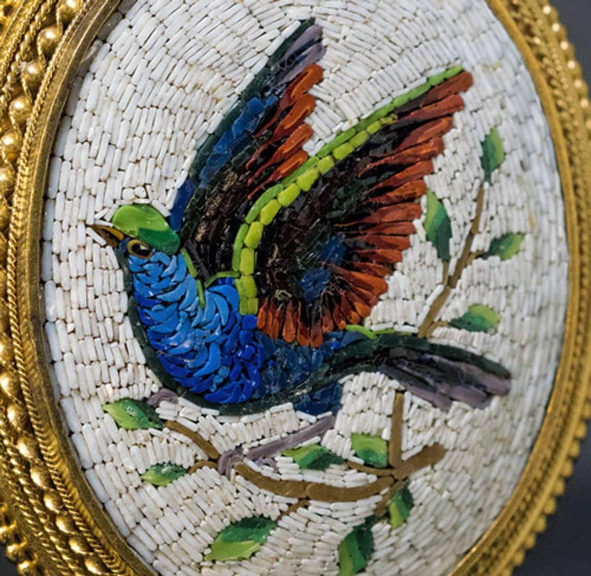 Circa 1860

A high quality large antique Italian micro mosaic pendant depicts a colorful bird of paradise. The micro mosaic plaque is set in a finely crafted Etruscan revival 18K gold bezel. The back of the pendant is fitted with a glazed picture
