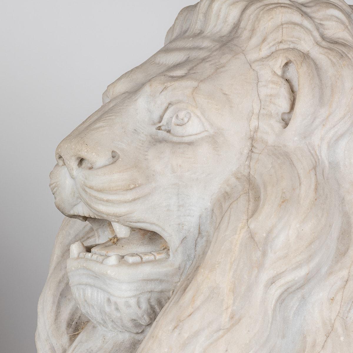 Antique 19th Century exquisite pair of Italian marble lions, each bearing a heraldic shield. Carved meticulously from Carrara marble, renowned for its purity and elegance, these majestic sculptures epitomise the opulence of the XIX century